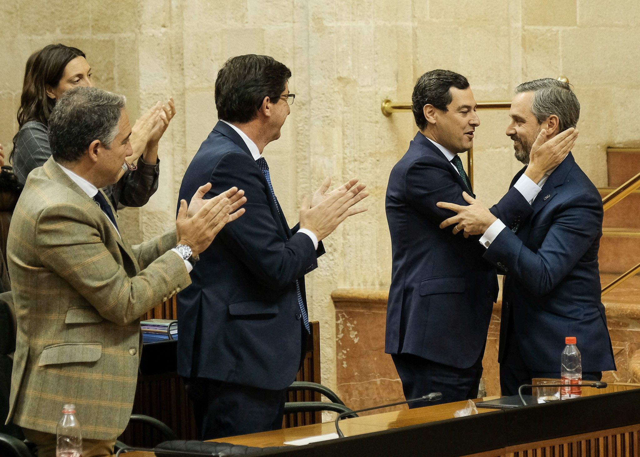 Moreno saluda al consejero de Hacienda, Juan Bravo, en presencia de Marín y Bendodo, en el pleno de Presupuesto de este pasado jueves. FOTO: PARLAMENTO DE ANDALUCÍA