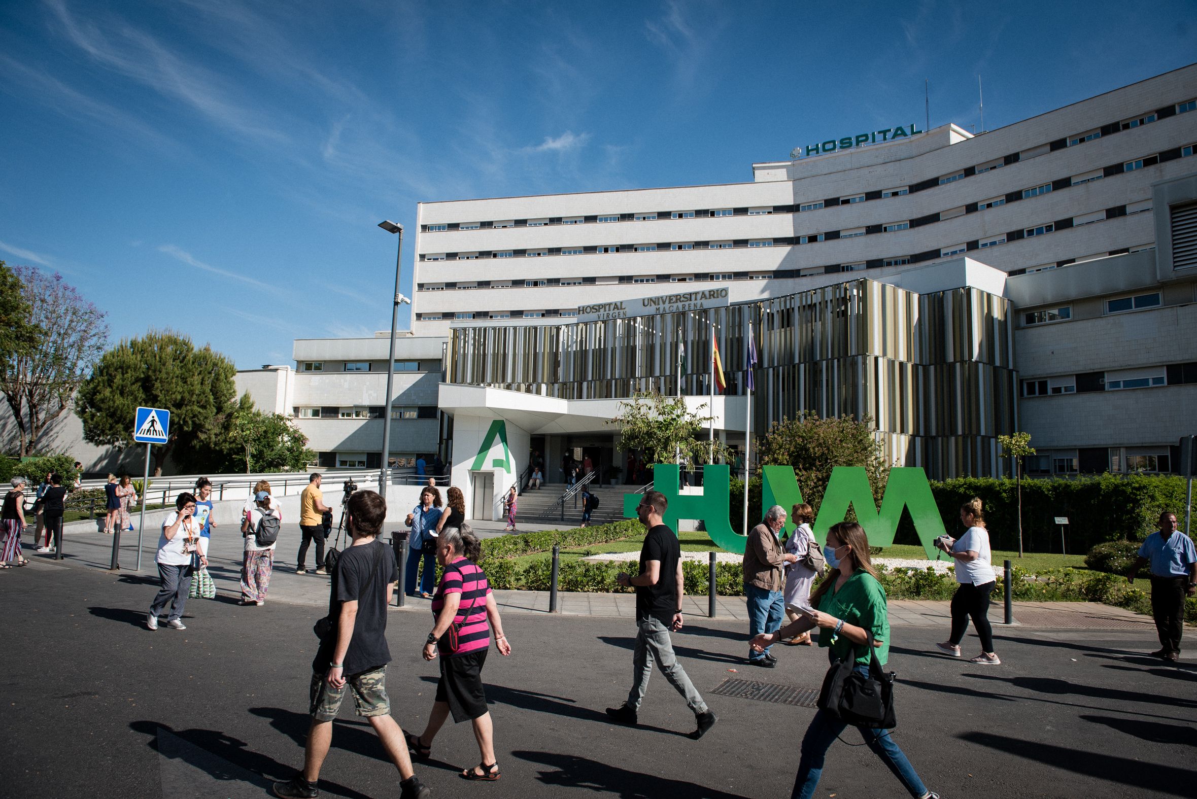 Varias personas y sanitarios pasean junto al hospital Virgen Macarena, dependiente del SAS.
