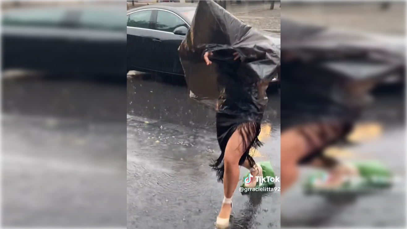 Una joven evita mojarse en la Feria de Córdoba. TIKTOK 