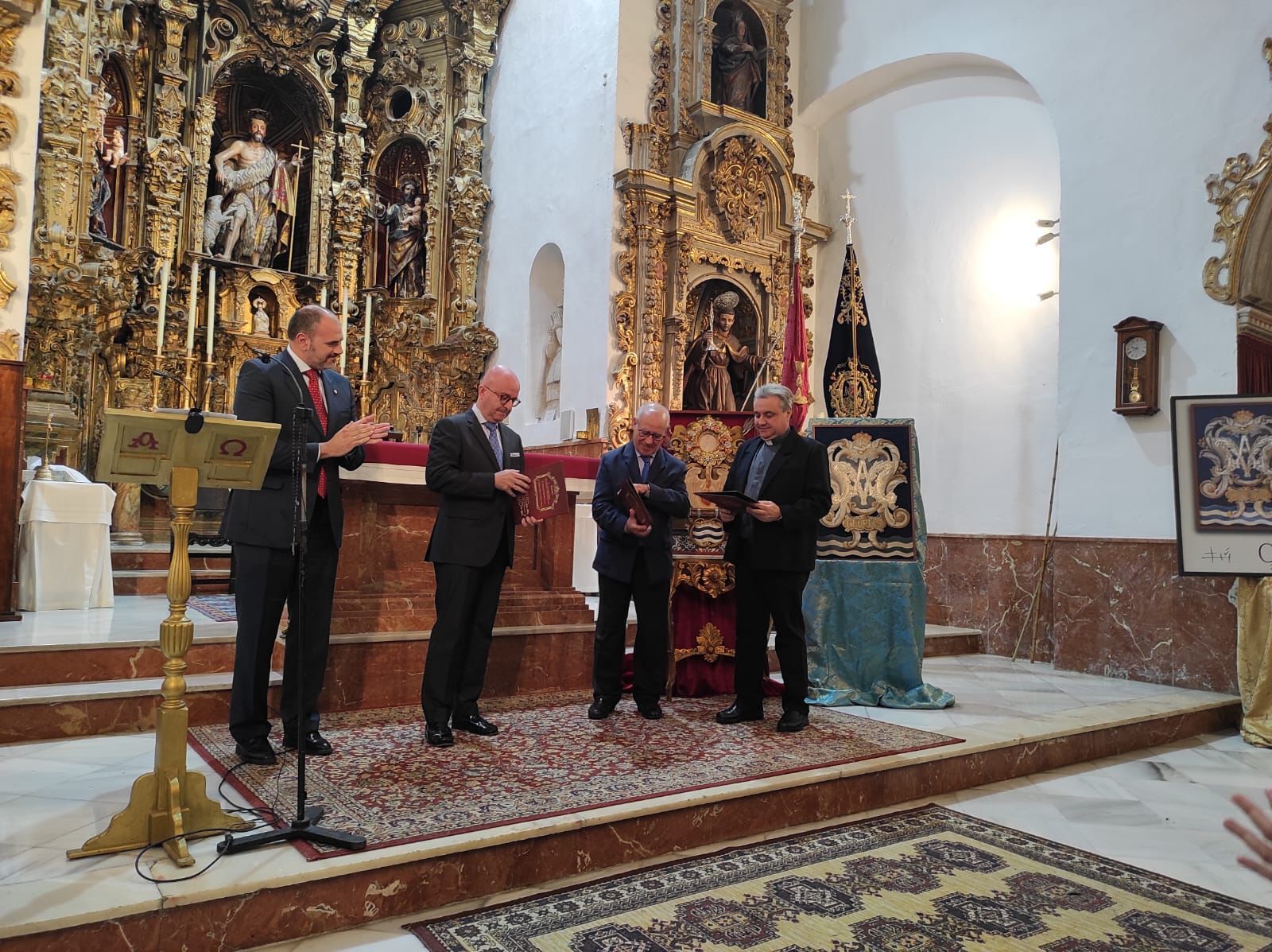 De Mora, Garrido y Sánchez-Romero recibiendo las pastas de la Exaltación Eucarística. 