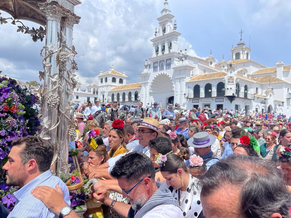 Centenares de peregrinos tras el simpecado con la ermita al fondo. 