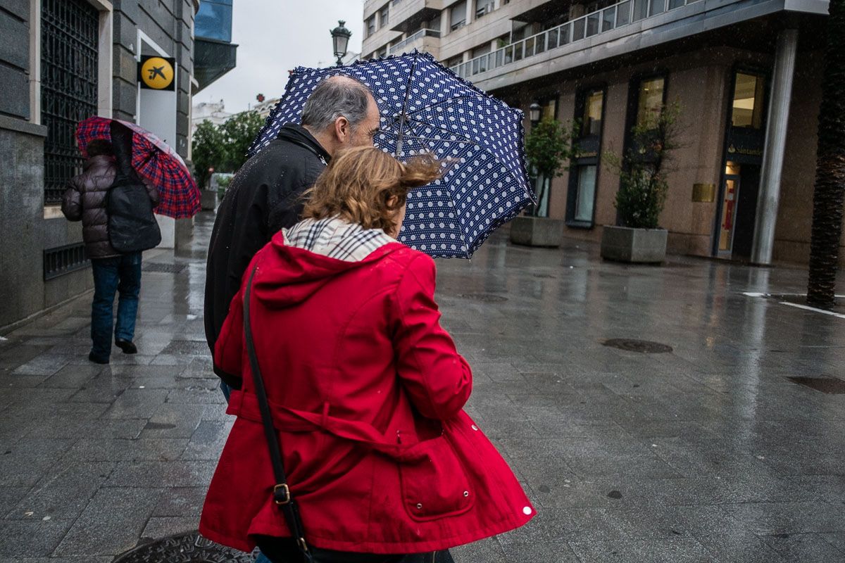 Una pareja se resguarda de las lluvias y el viento en una imagen de archivo.