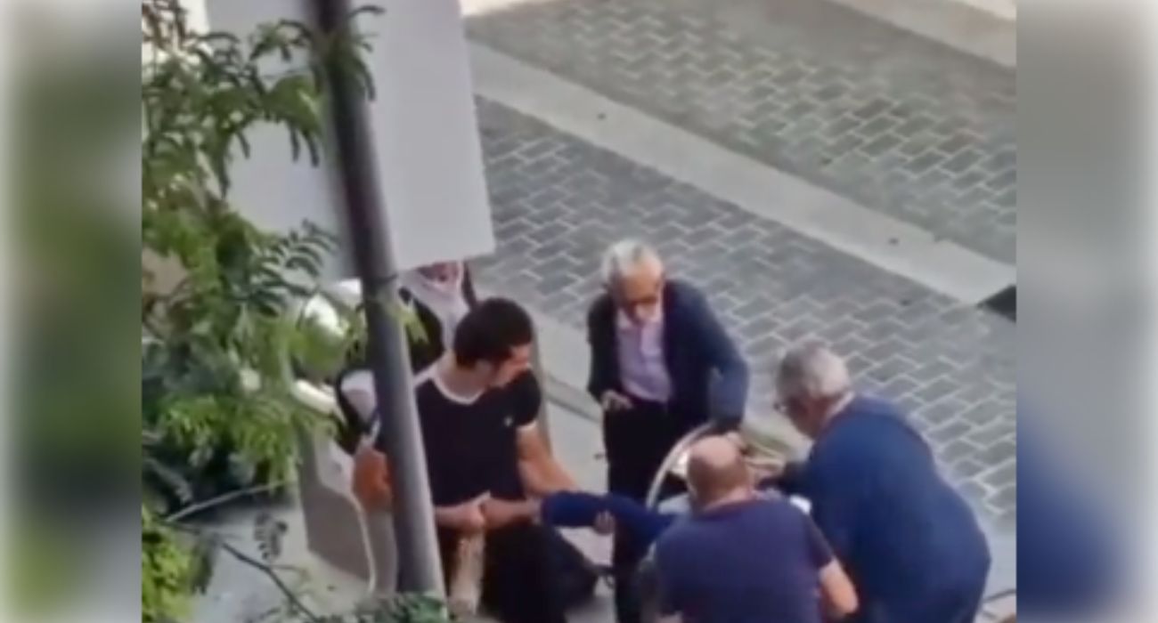 Varias personas intentan sacar a un hombre de un contenedor de basura.