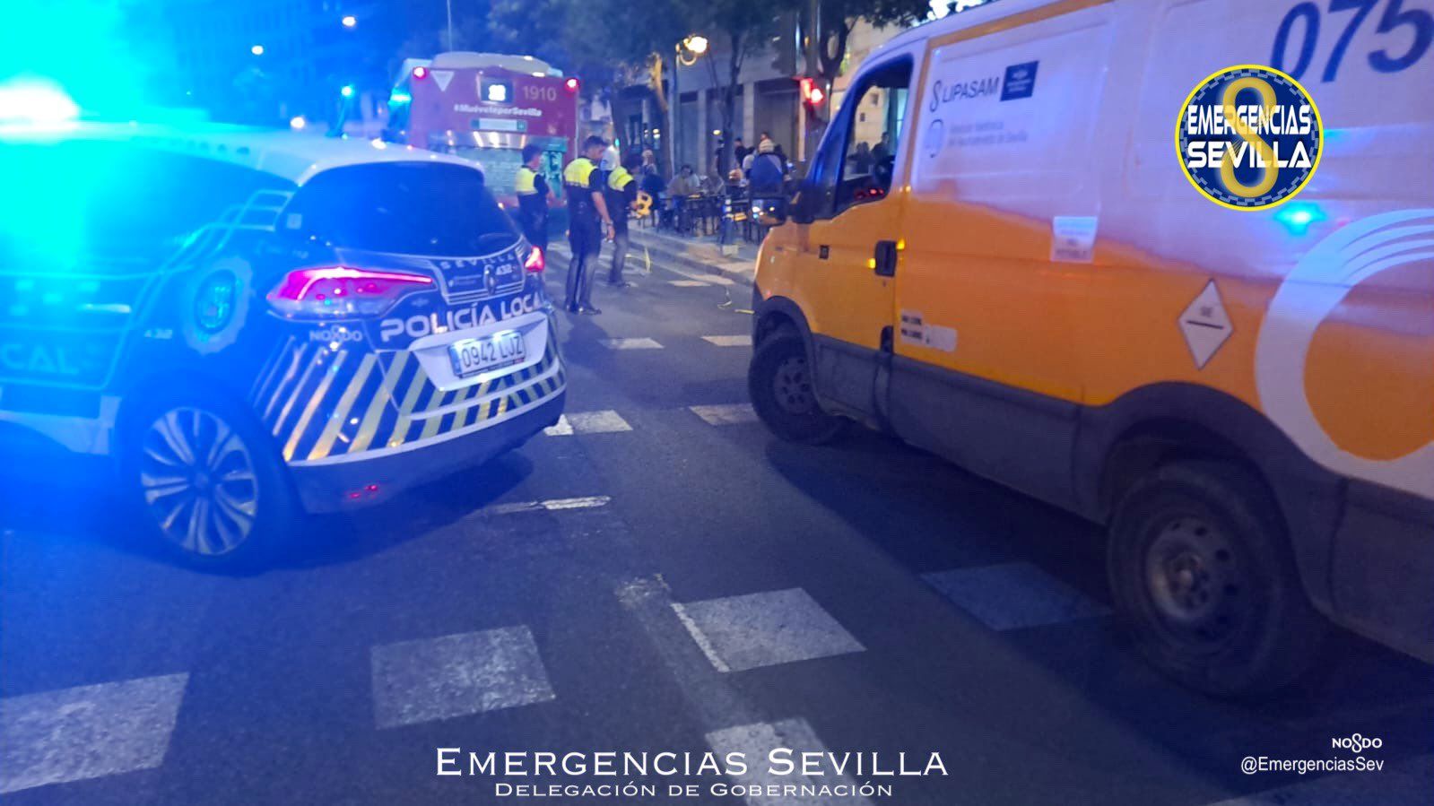 Una ambulancia y un coche de la Policía Local de Sevilla, detrás del autobús que ha atropellado a una mujer.