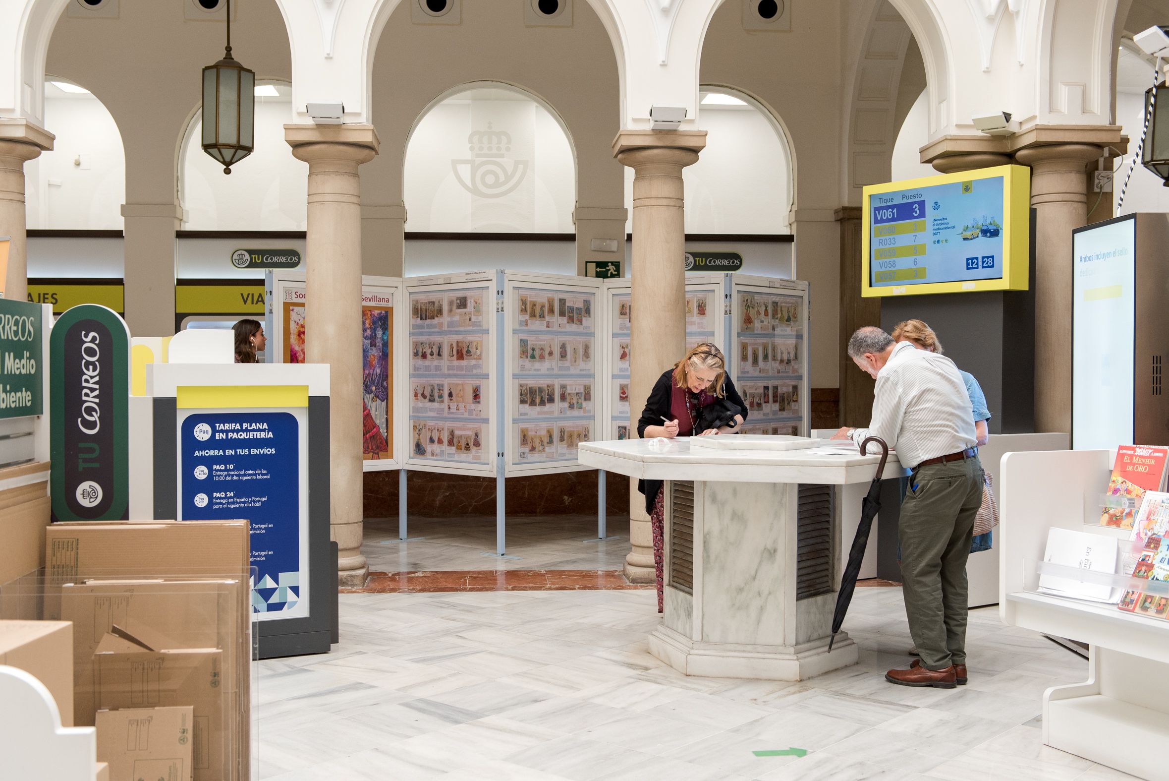 Personas ejerciendo el voto por correo en la oficina de Correos de Sevilla..