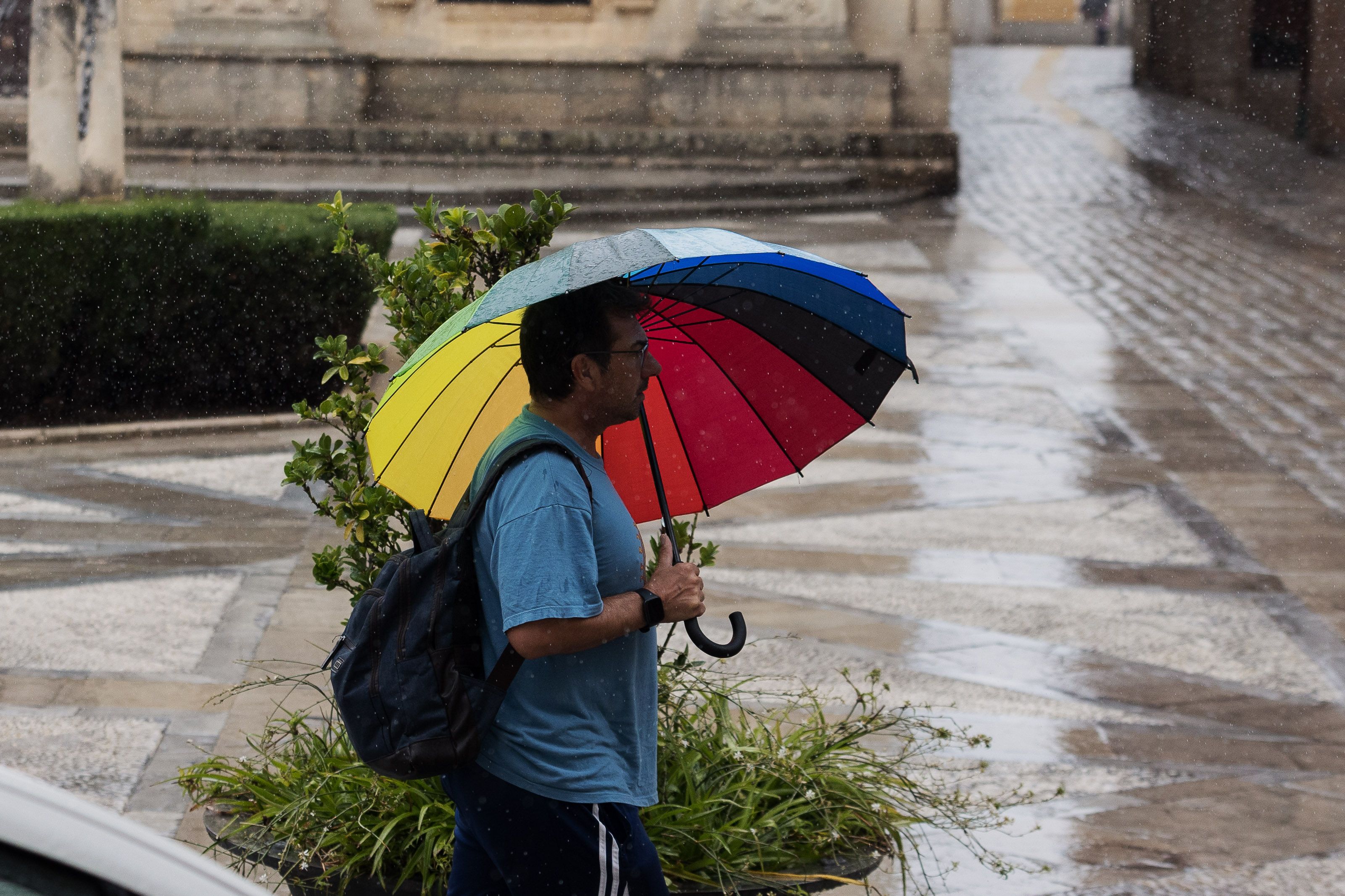 Un ciudadano pasea con paraguas en mano un día de lluvia.