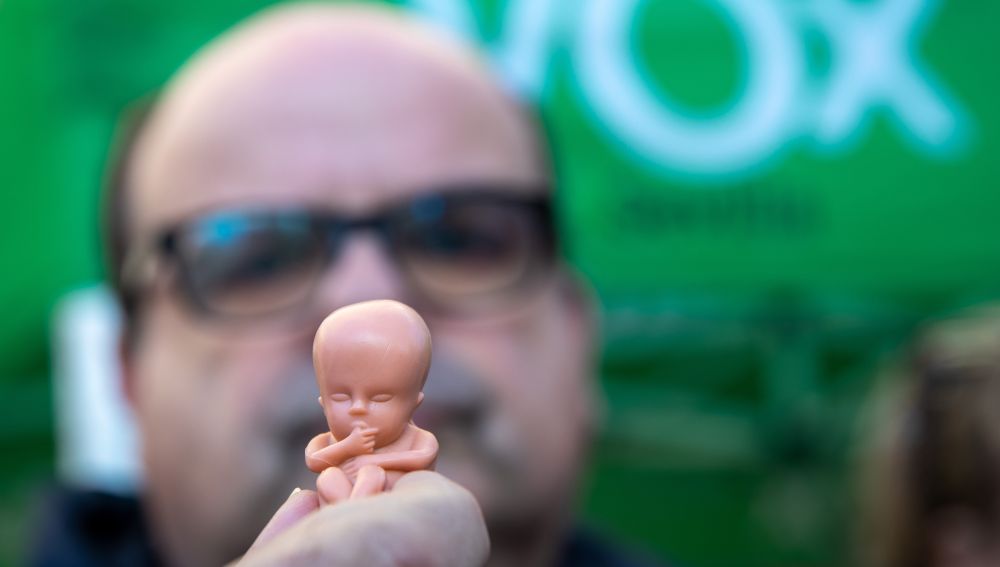 Un miembro de Vox muestra una de las réplicas de un feto que se han repartido.