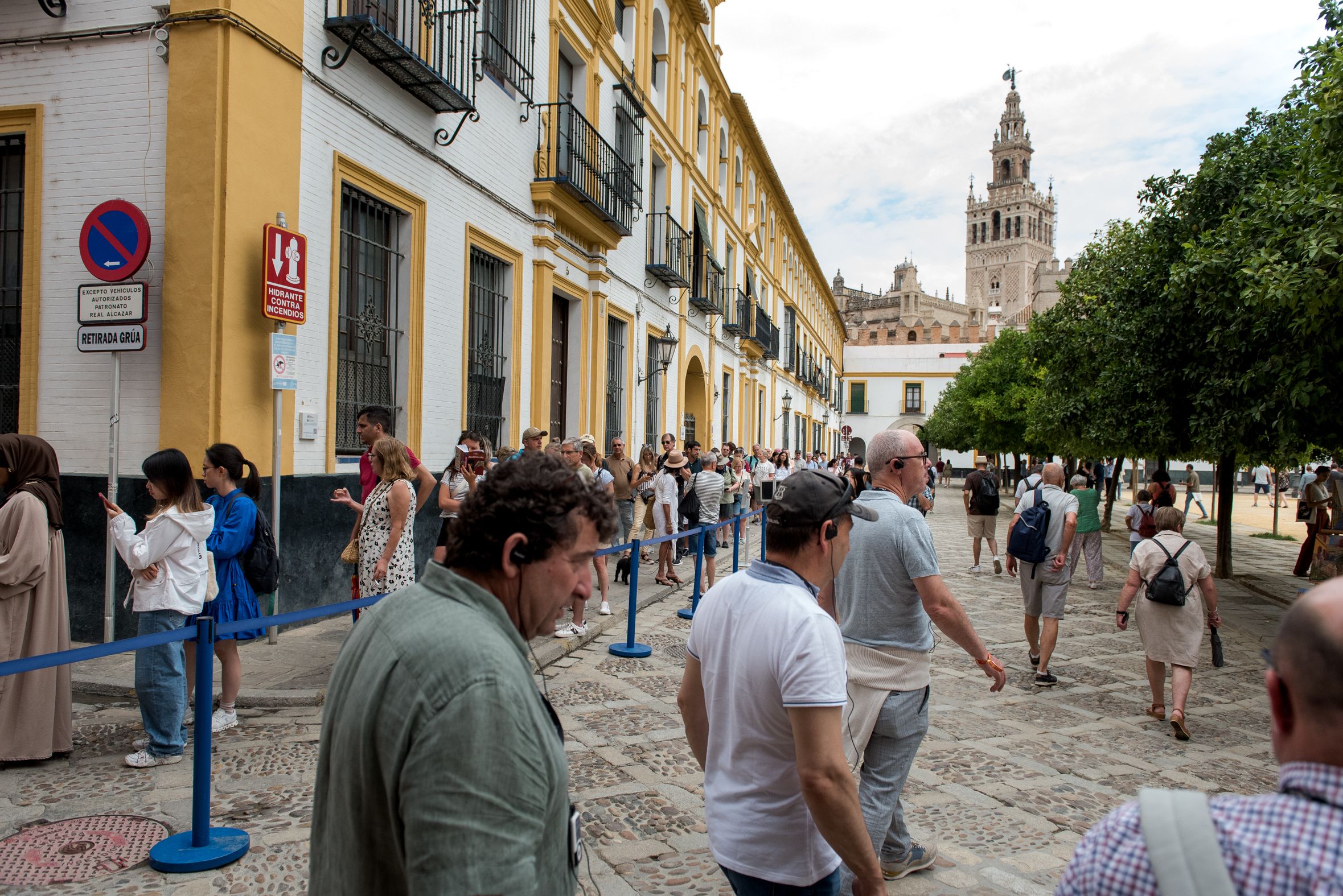 Un grupo de turistas con la Giralda al fondo, uno de los monumentos más conocidos de Andalucía.