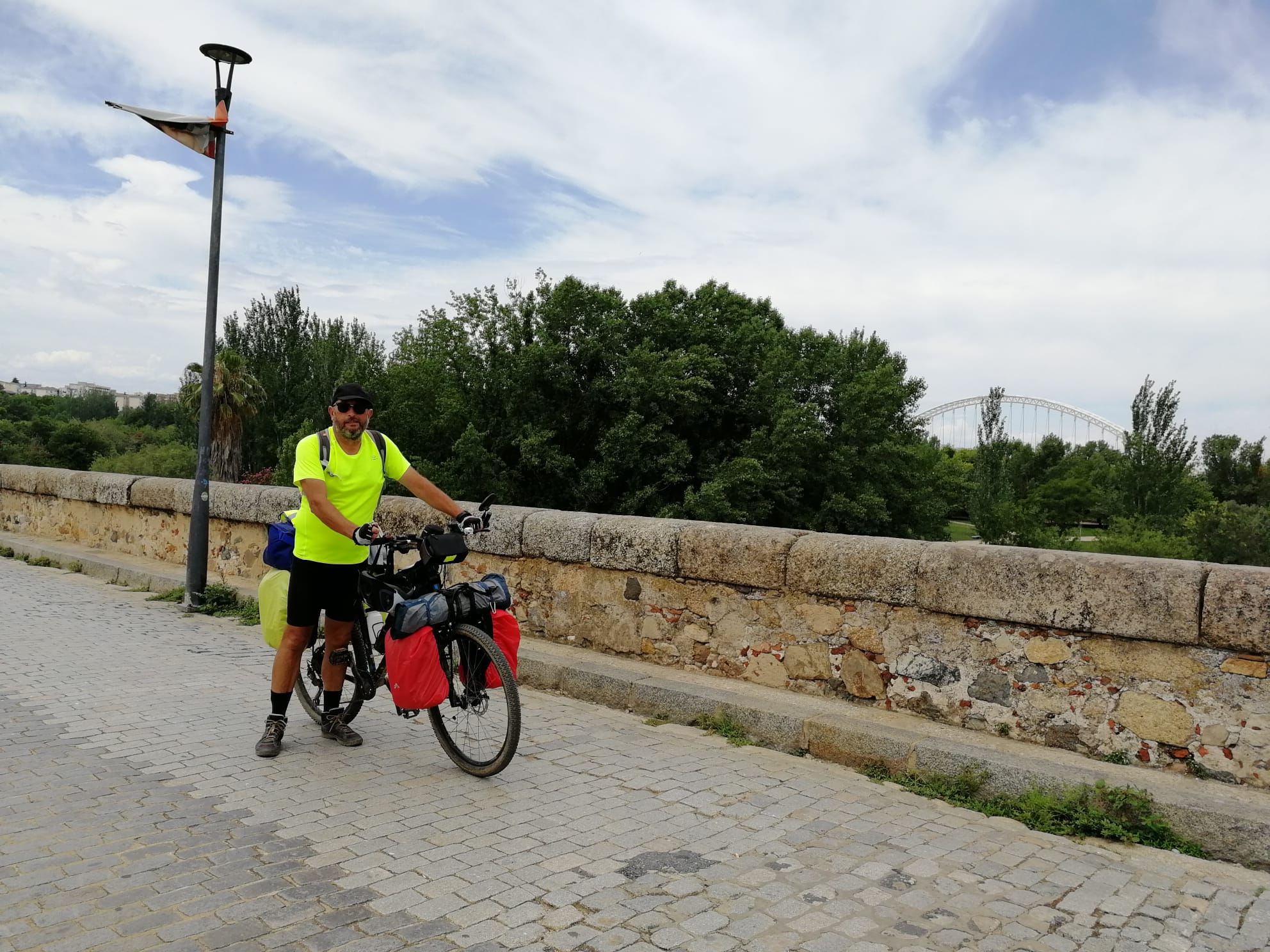 Germán junto a su bicicleta sobre el Puente Romano de Mérida. 