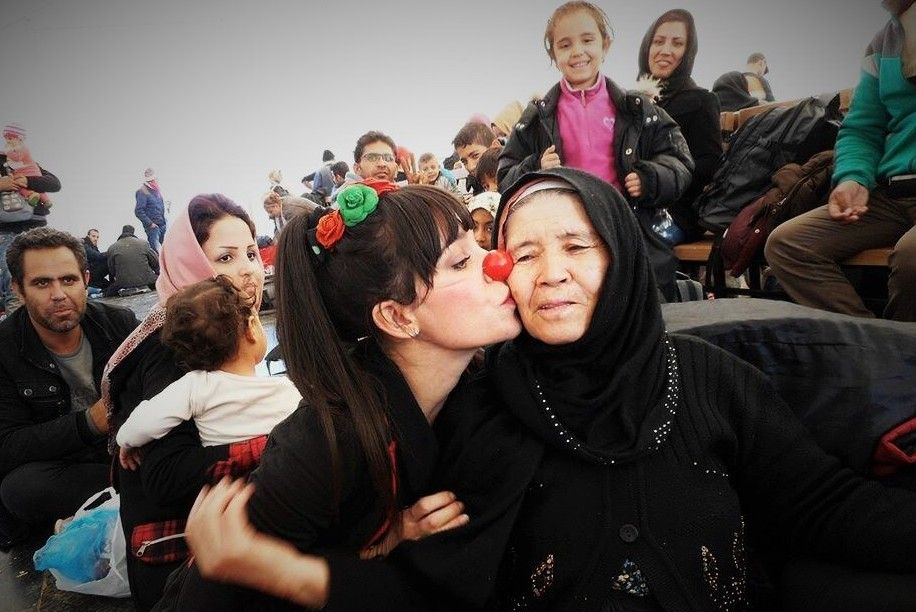 Lola Mento, besando a una mujer en un campo de refugiados de Macedonia.