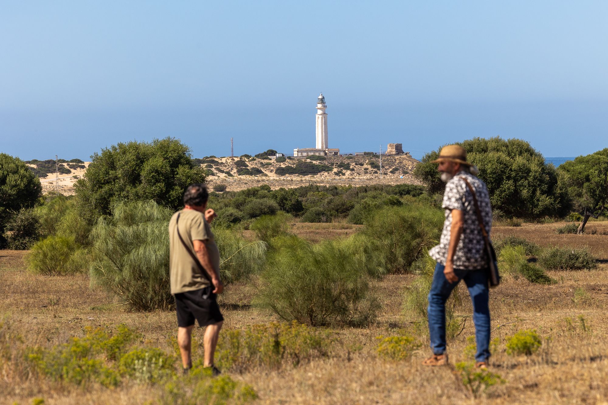 Antonio Casado y José Antonio Mármol, de la asociación Costa de la Luz de Zahora, con el faro de Trafalgar al fondo.