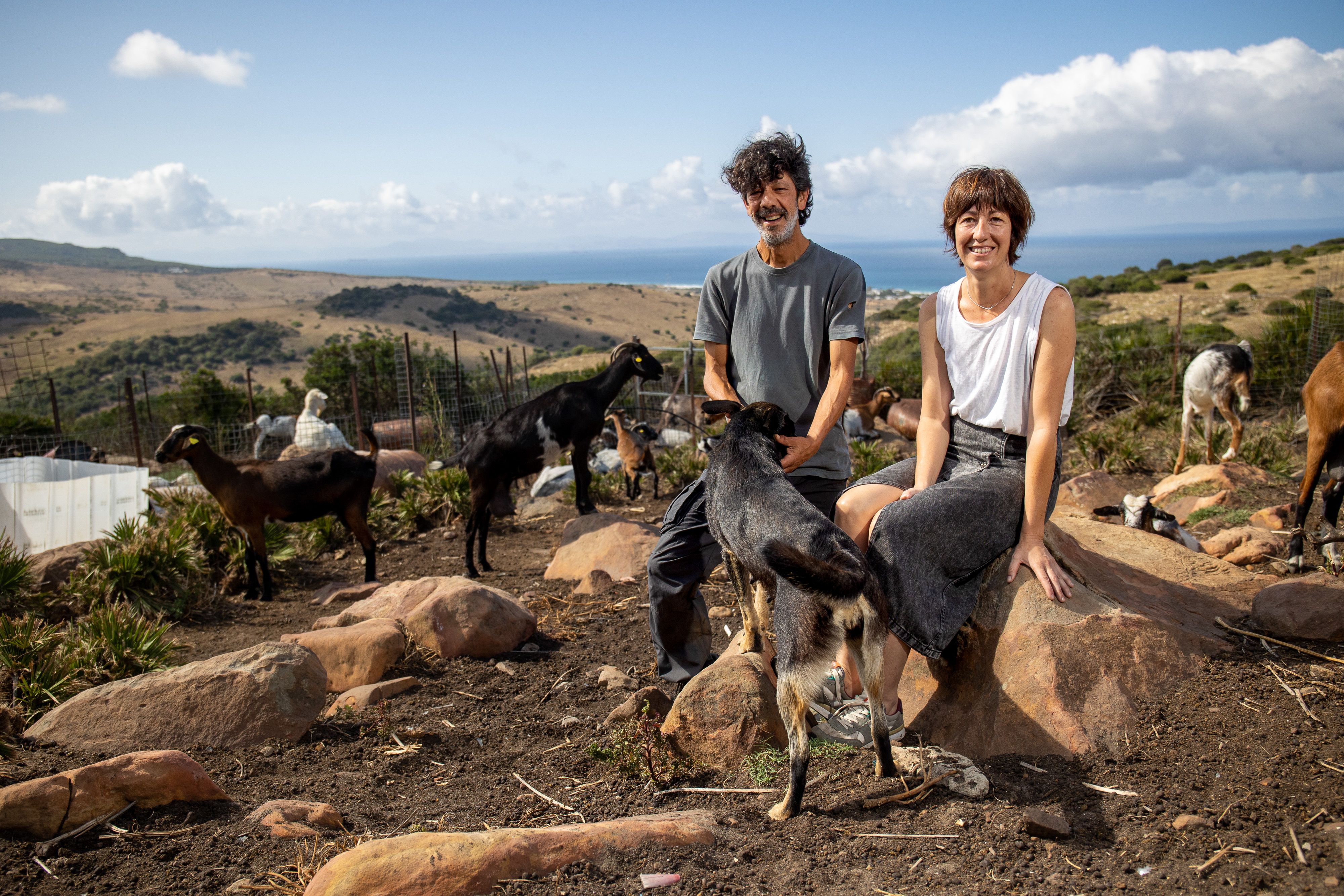 Mario y Lorena, junto a su rebaño de cabras payoyas, en la quesería El Cabrero, con la ensenada de Bolonia y el Norte de África al fondo.