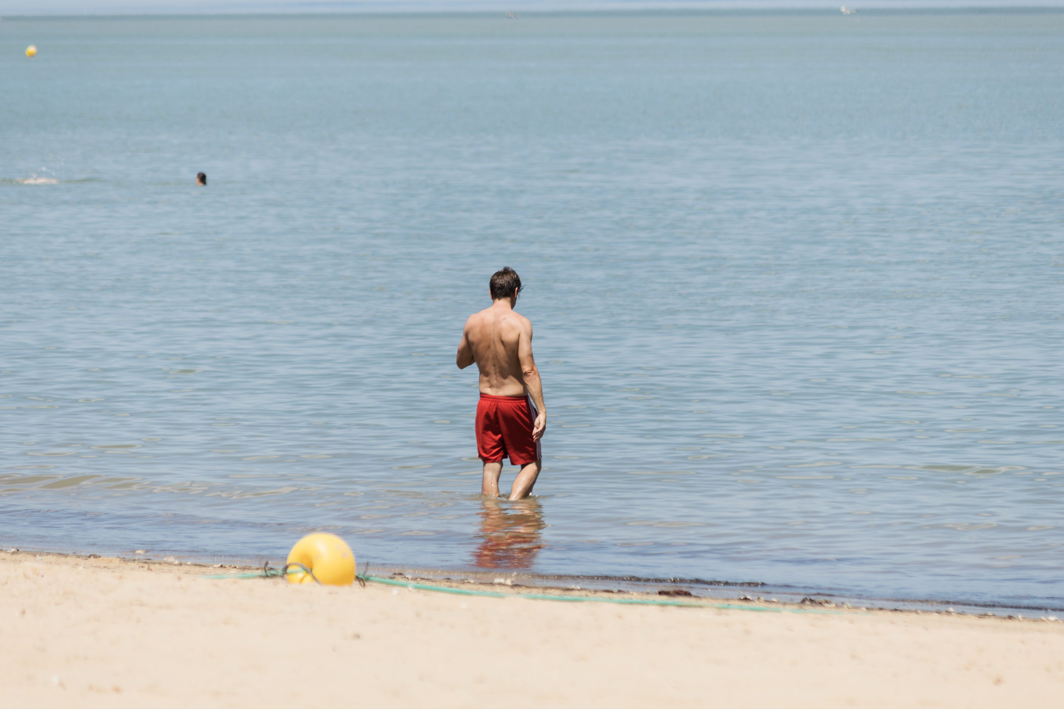 Una persona se baña en una playa de la provincia de Cádiz. Los protectores de sol afectan a la fauna acuática