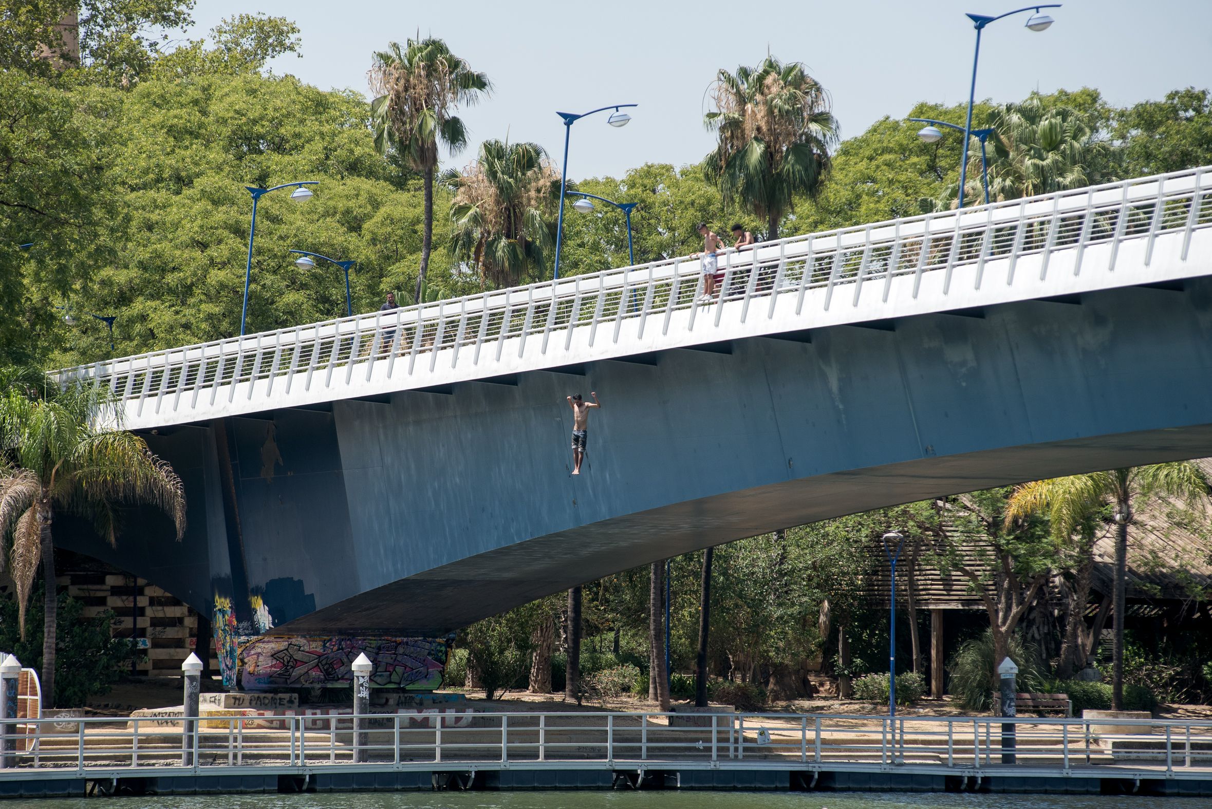 Una persona salta al río desde el puente. 