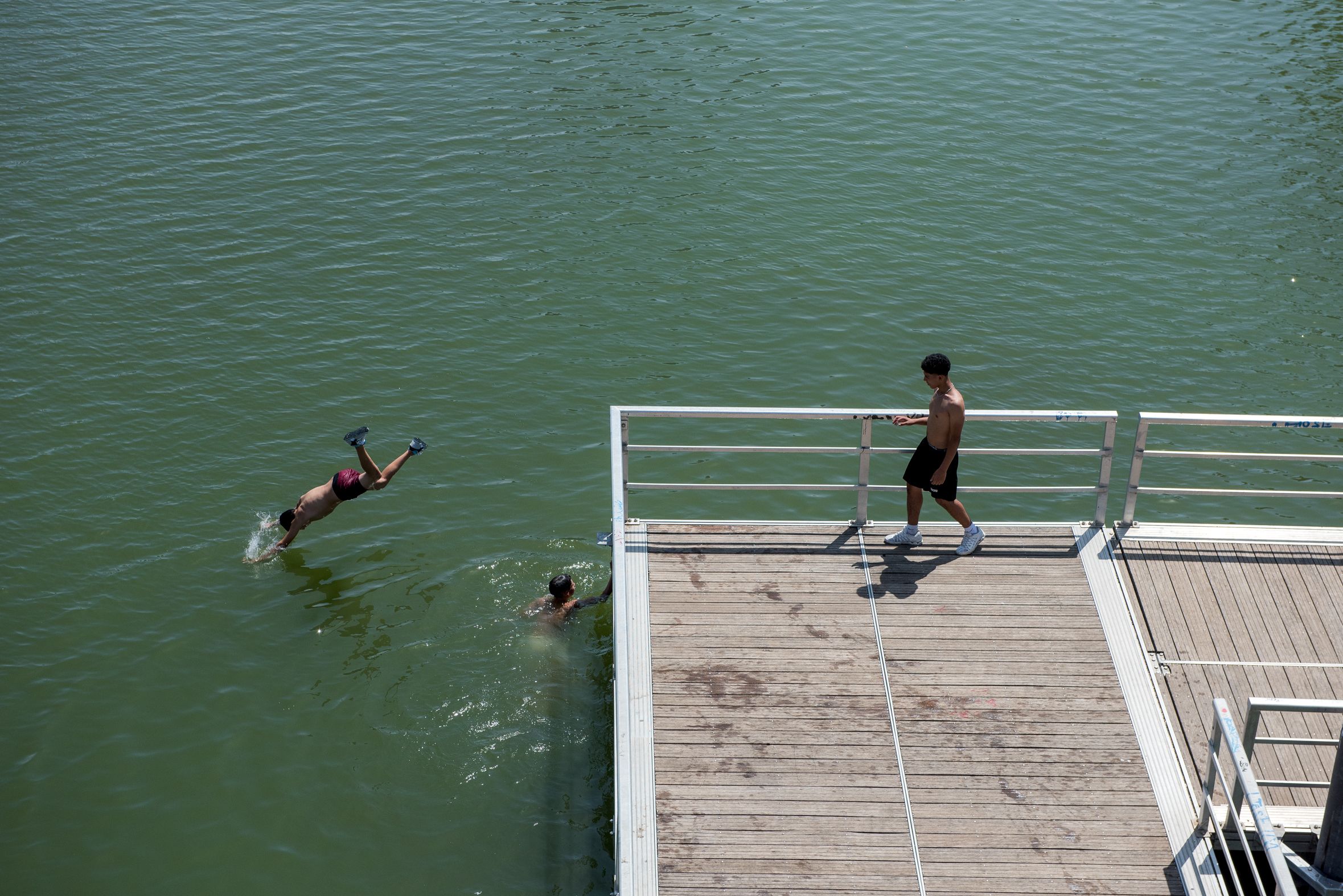 Varias personas se bañan en el río Guadalquivir en plena ola de calor en Sevilla por las altas temperaturas.