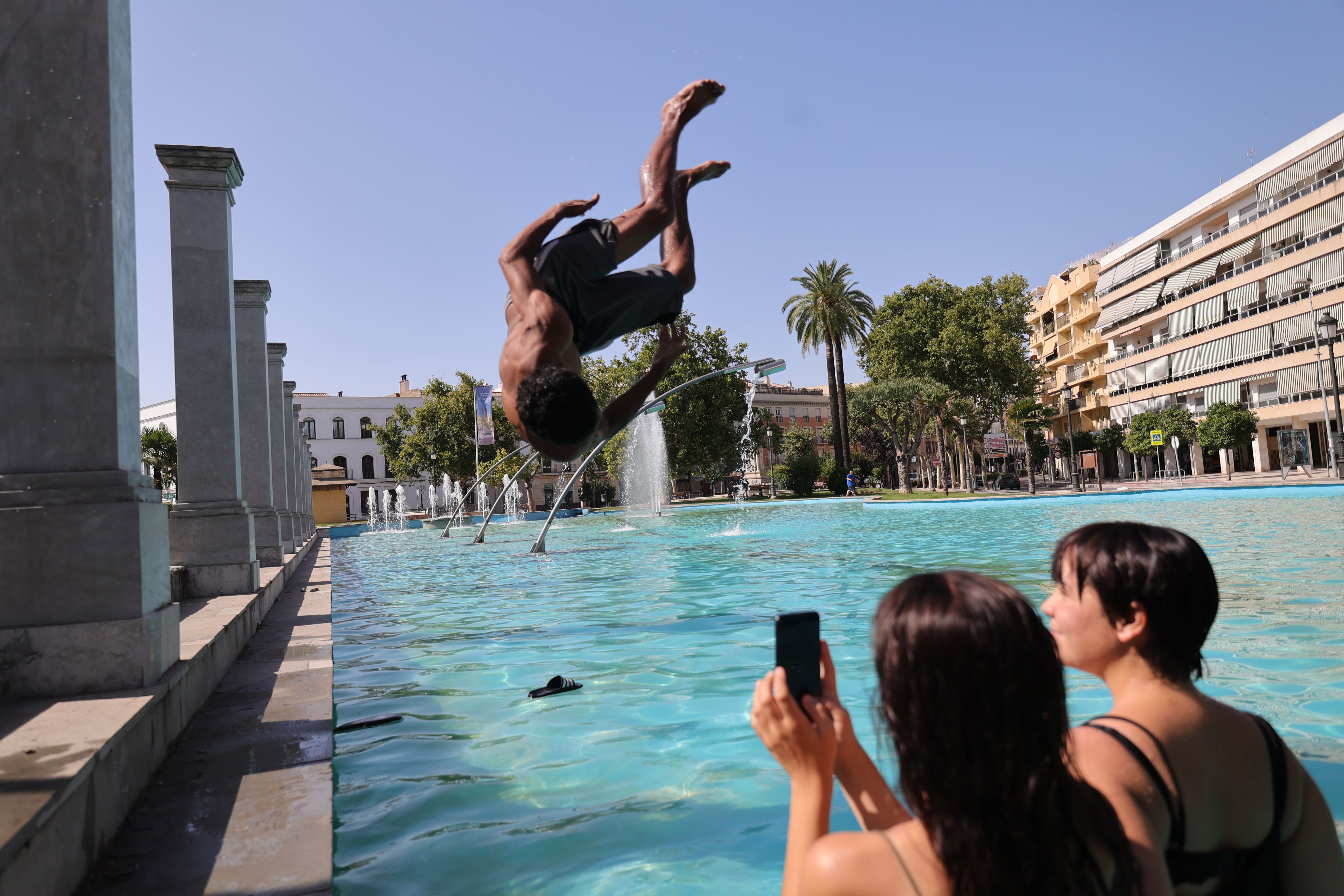 Un chico se lanza a la fuente del Mamelón en Jerez durante una ola de calor.