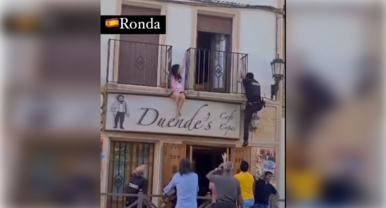 Momento en el que un agente de Policía sube al balcón para rescatar a la mujer.