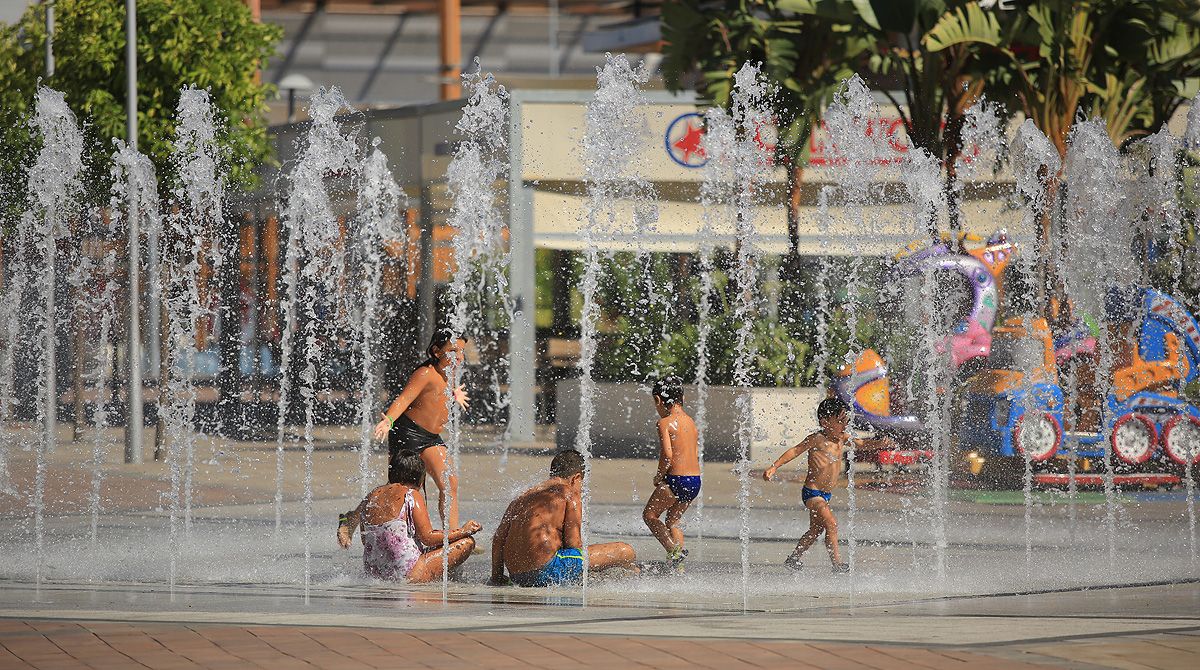Niños refrescándose en las fuentes del Luz Shopping, en Jerez. 