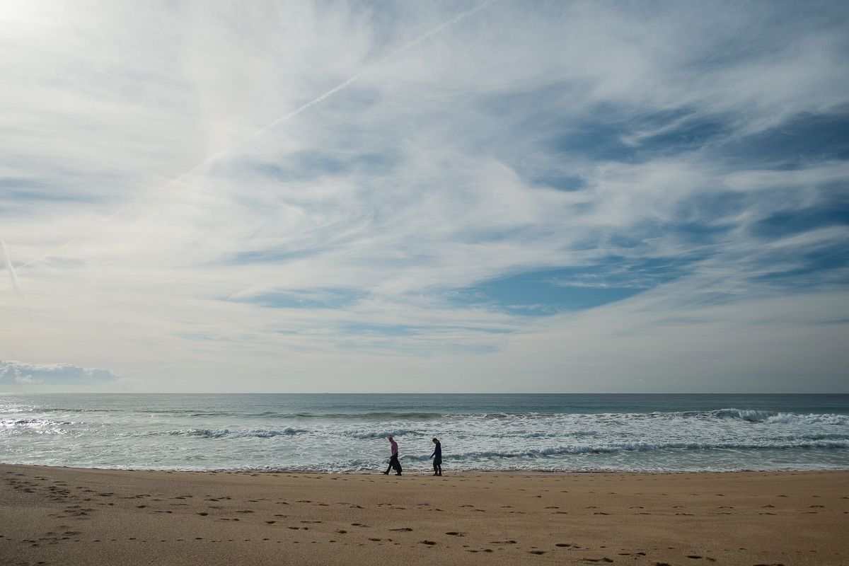 Dos personas pasean por la playa de Mangueta de Barbate.