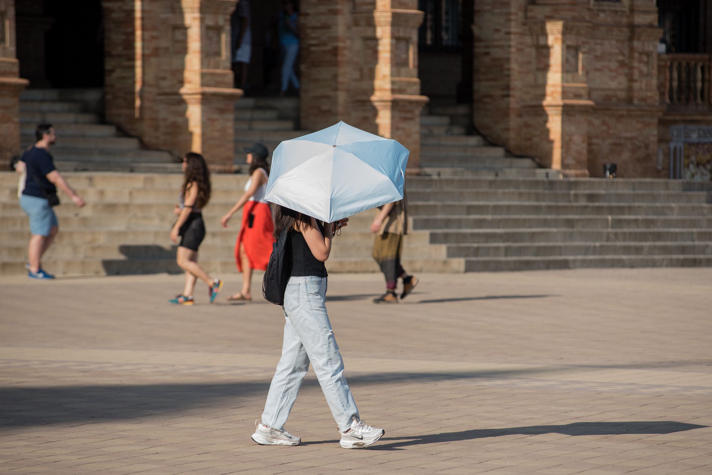 Una mujer se protege de una ola de calor del verano por las altas temperaturas.