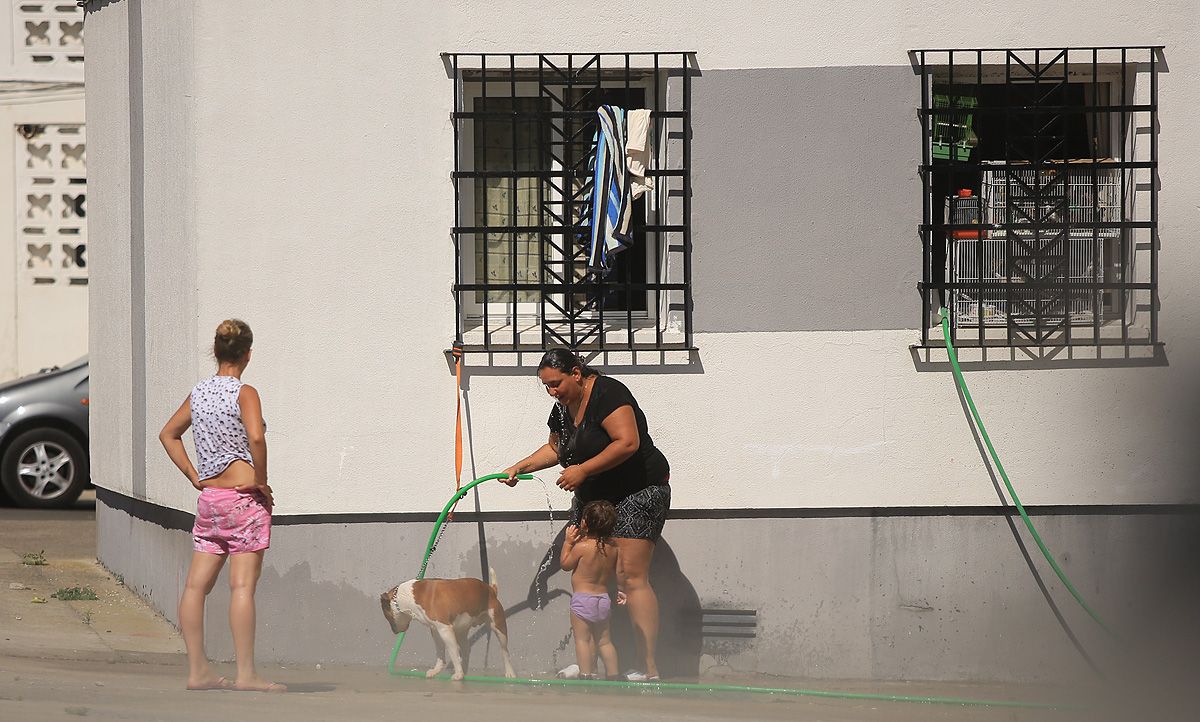 Una mujer remojándose  en la calle con una manguera. FOTO: JUAN CARLOS TORO. 