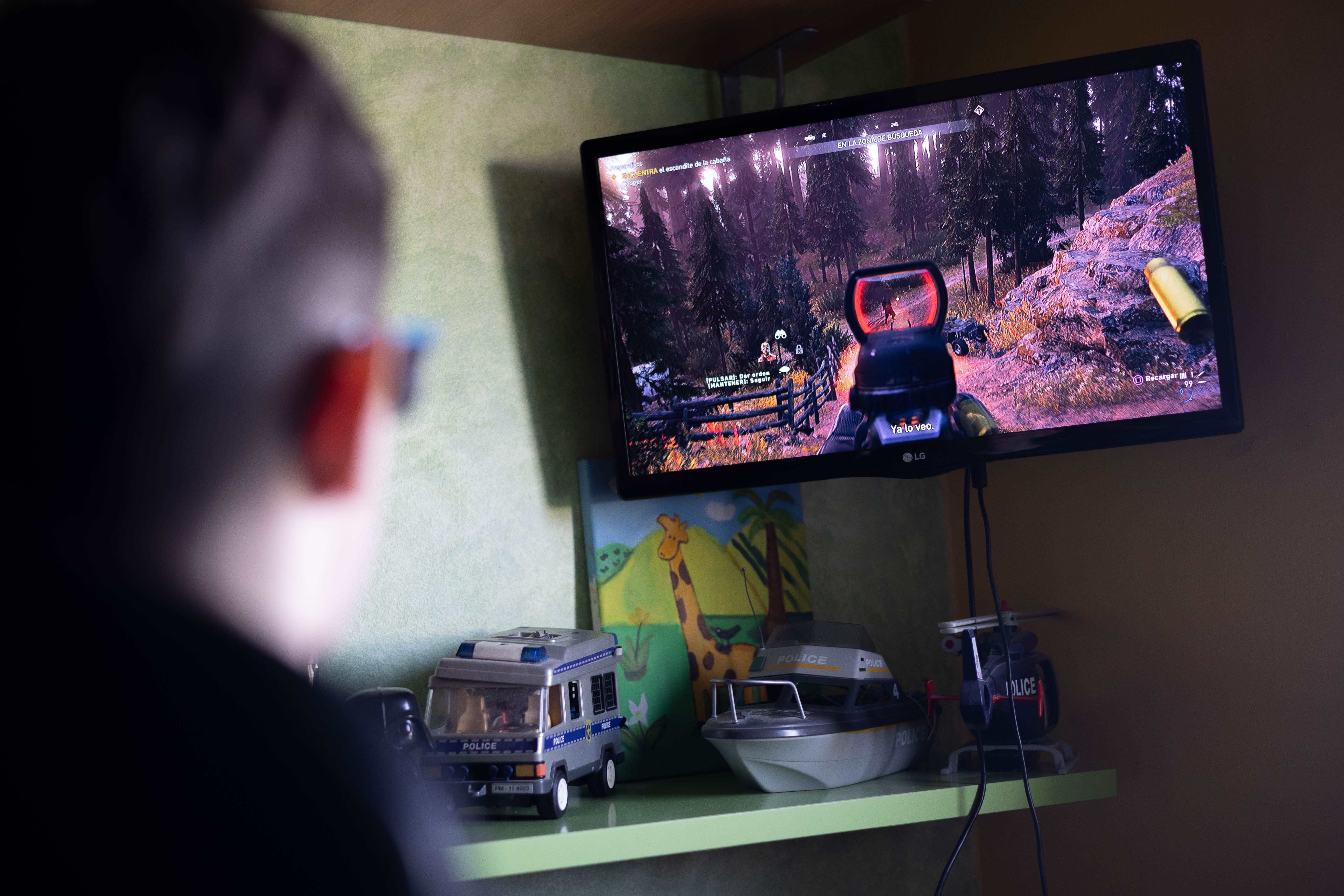Un joven jugando a un videojuego en su cuarto.  
