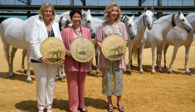 Posando con una replica a gran tamaño de la moneda ante una cobra de yeguas cartujanas.
