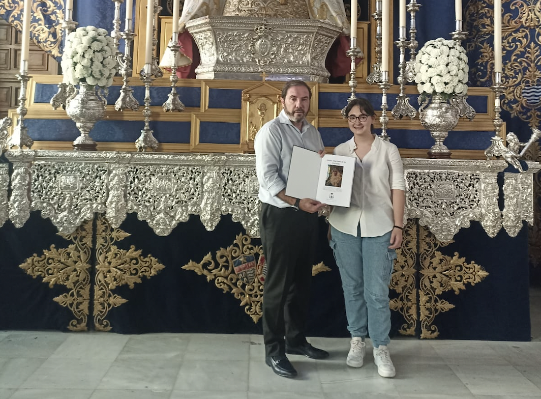 El hermano mayor recibiendo las partituras de la marcha de mano de su autora. 