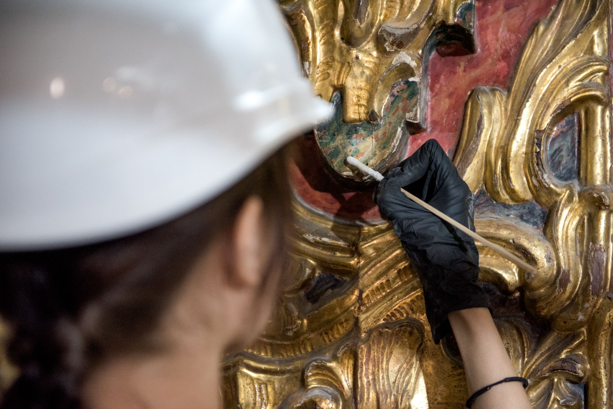 Minucioso trabajo de recuperación sobre el policromado de una zona tallada. MAURI BUHIGAS