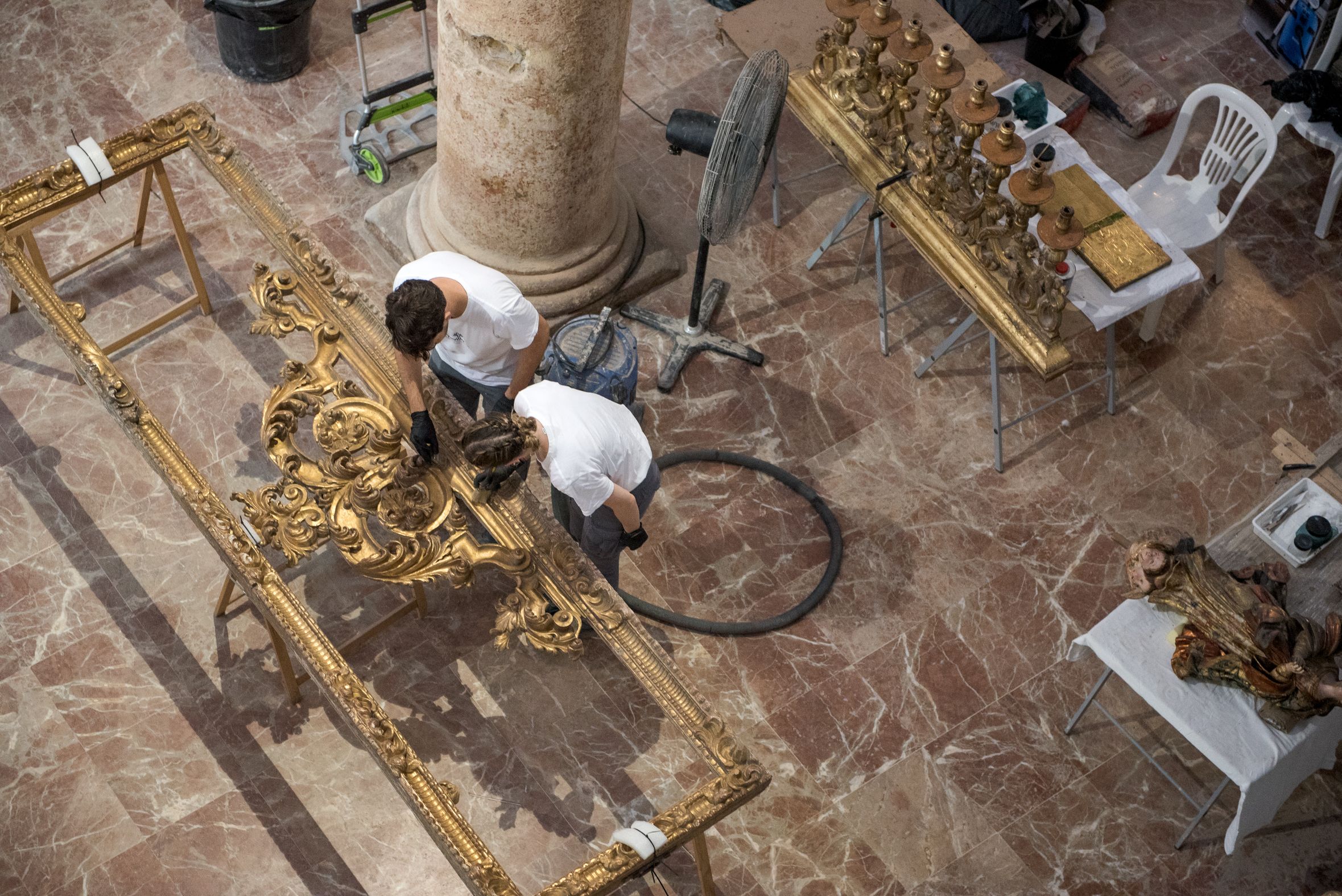 Dos participantes en el programa empleados en una parte del retablo de Santiago.     MAURI BUHIGAS