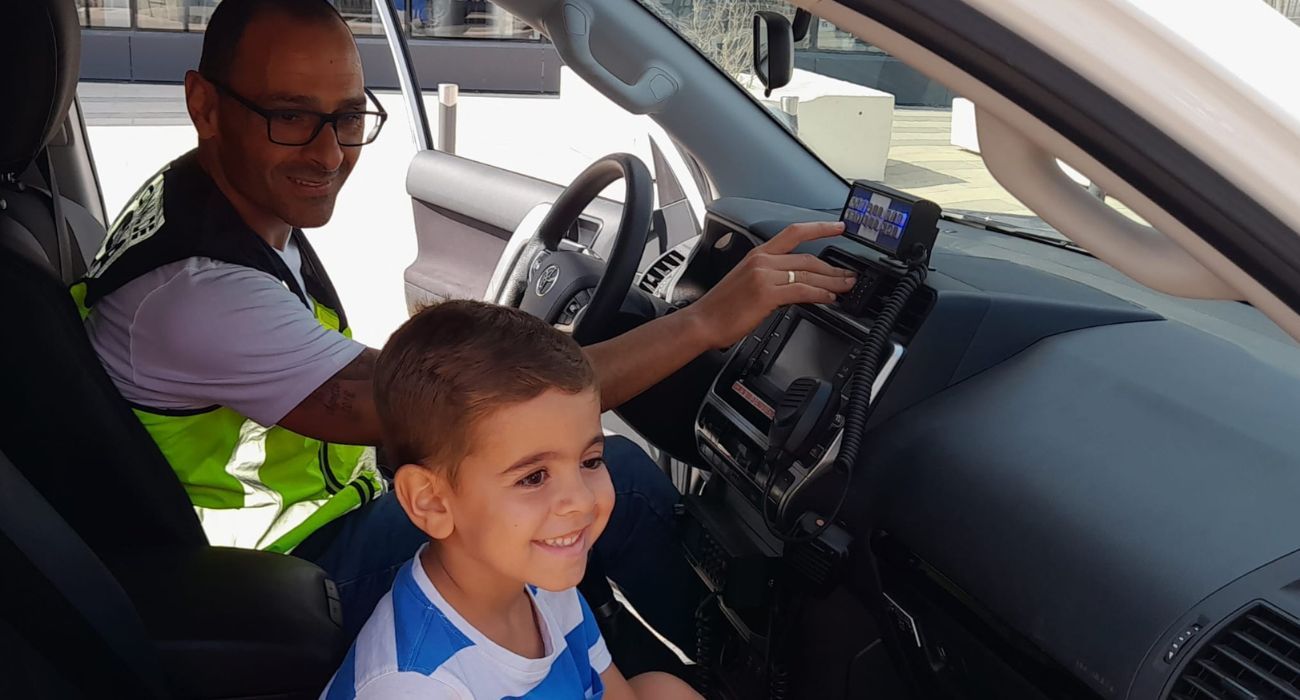 El pequeño Fabio, en el coche policial junto a Octavio, el agente que lo trasladó de urgencia a un centro sanitario.
