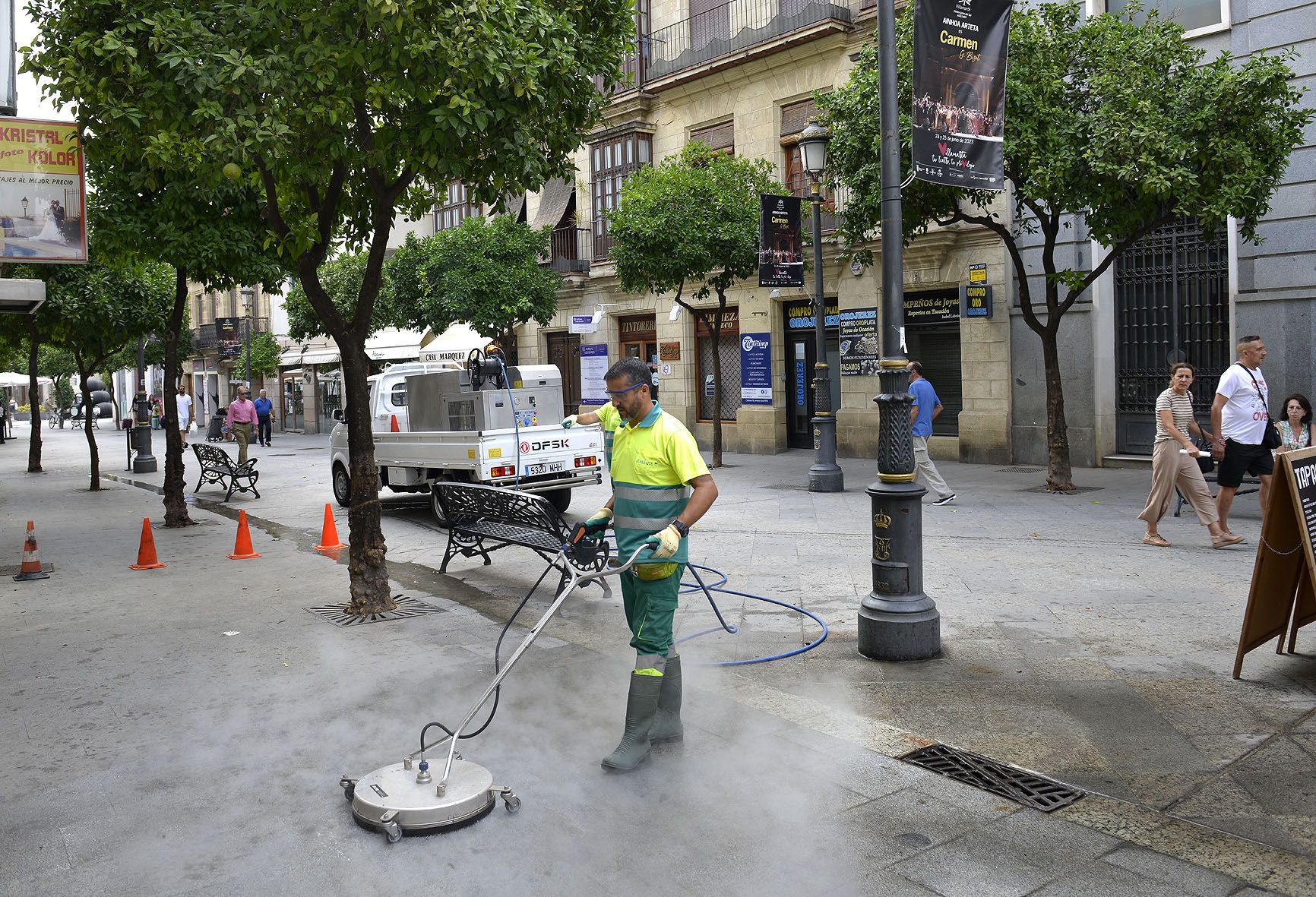 Personal de limpieza retirando suciedad del pavimento de la calle Lancería de Jerez.