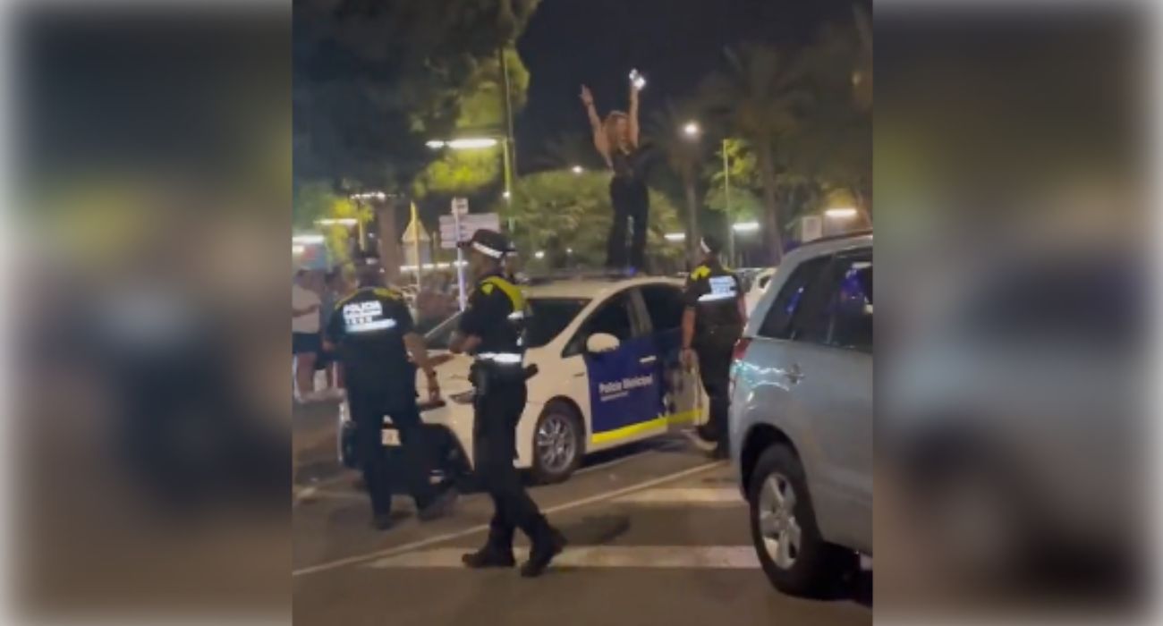 Una mujer baila en lo alto del techo de un coche policial.
