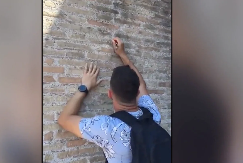 Ivan Dimitrov, escribiendo su nombre y el de su pareja en el Coliseo romano
