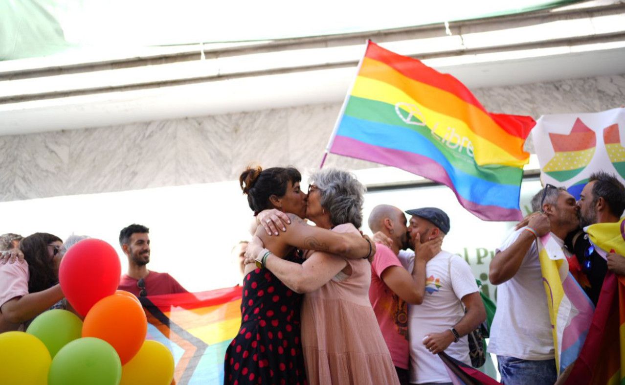 Teresa Rodríguez y Pilar González se besan frente a la sede de Vox en El Puerto. ADELANTE