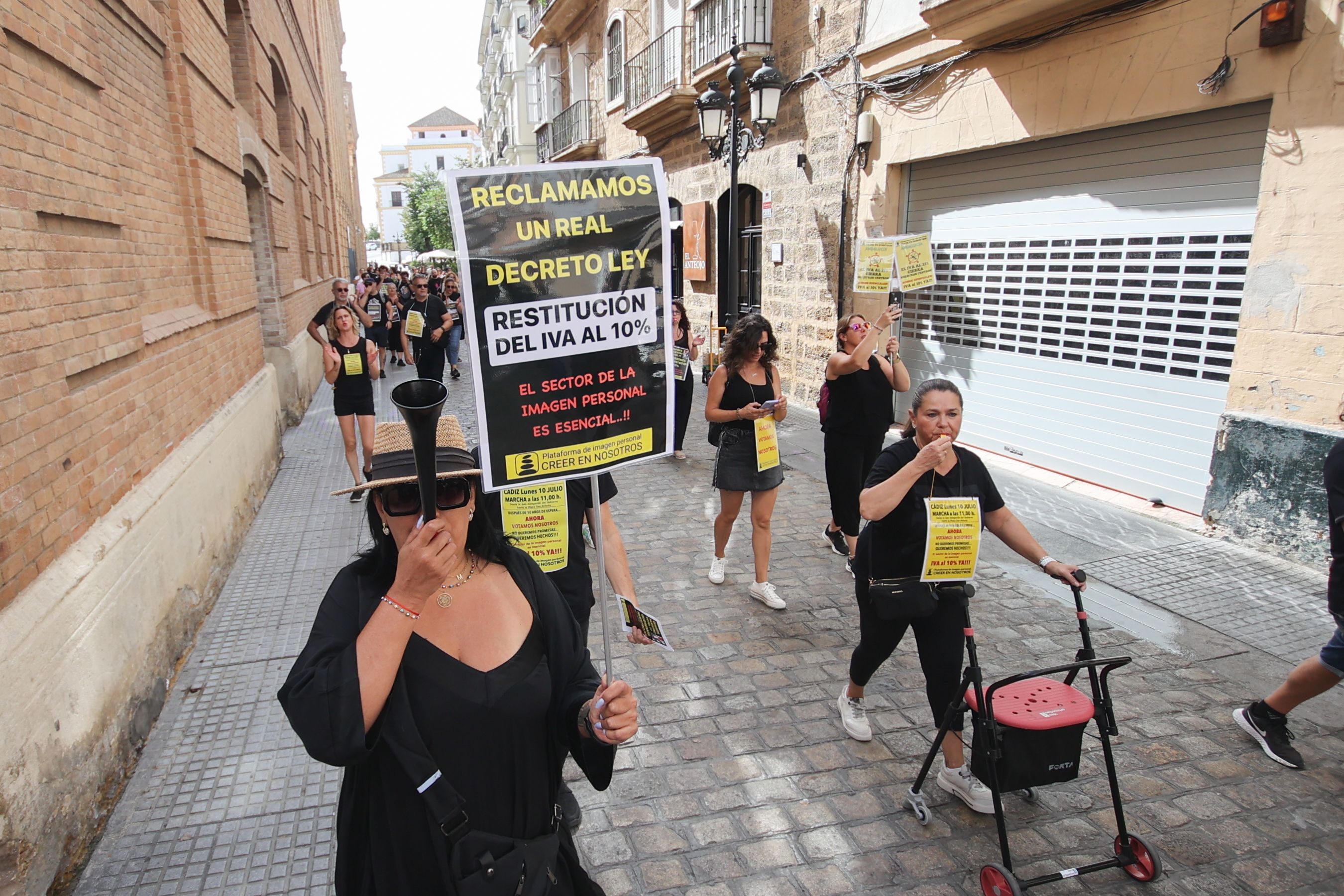 La marcha reivindicativa del sector de la imagen personal ha recorrido Cádiz. 