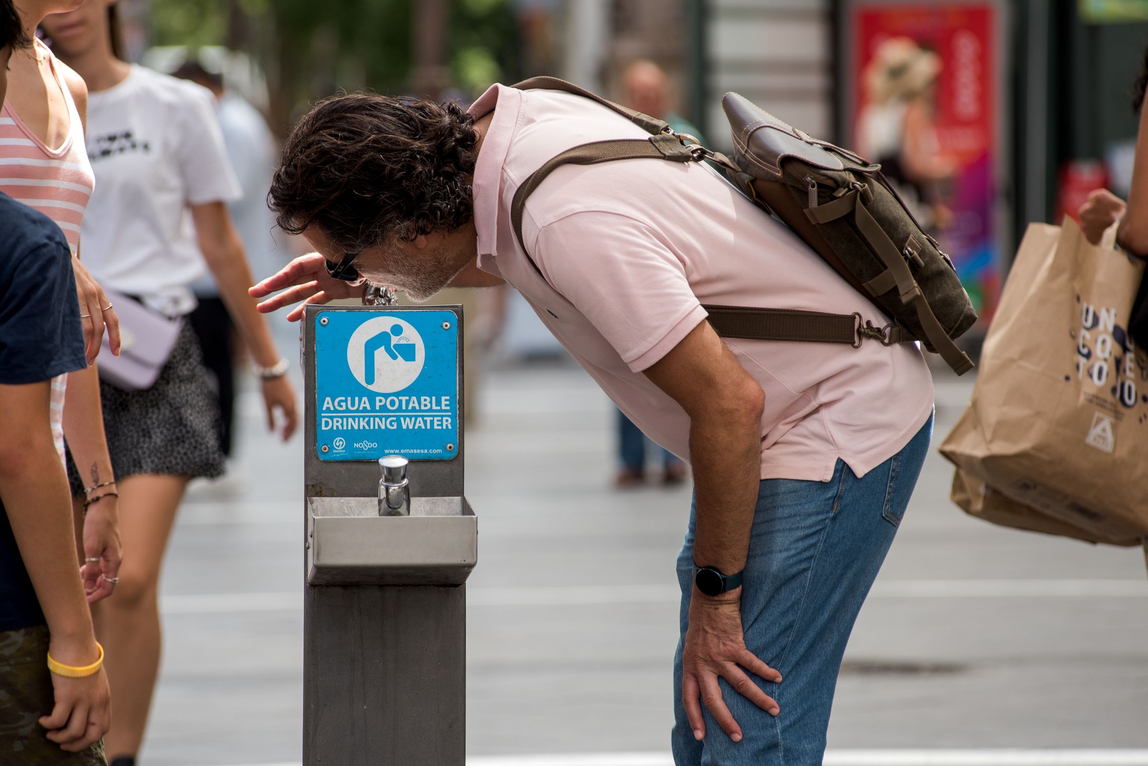 Un hombre bebe de una fuente pública en Sevilla durante una ola de calor.  La Junta ha aprobado un nuevo decreto de sequía.