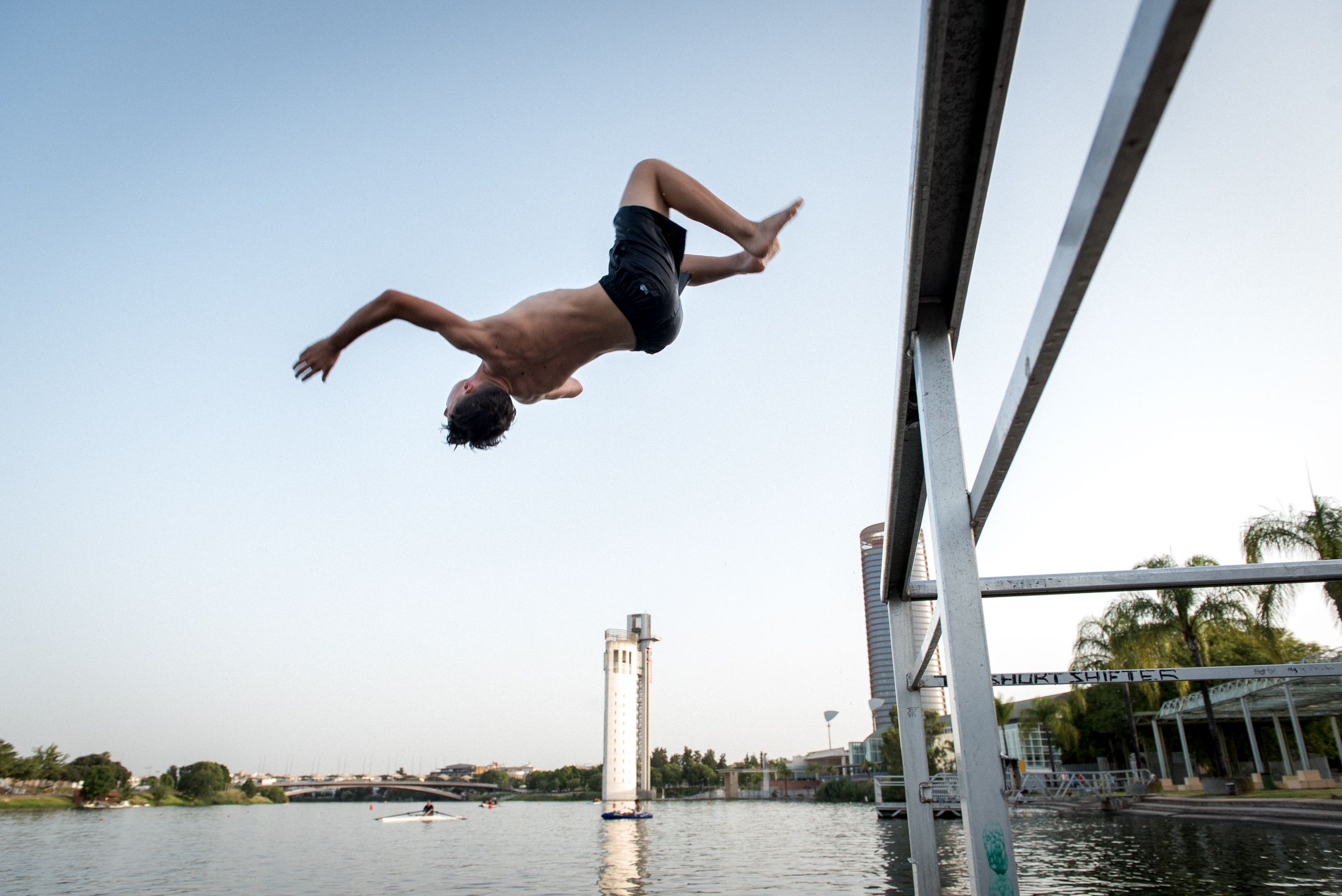 Un joven se lanza al Guadalquivir para combatir el calor, en Sevilla.