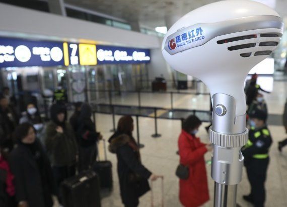 Un termómetro toma la temperatura a los pasajeros de un vuelo en China. FOTO: XINHUA