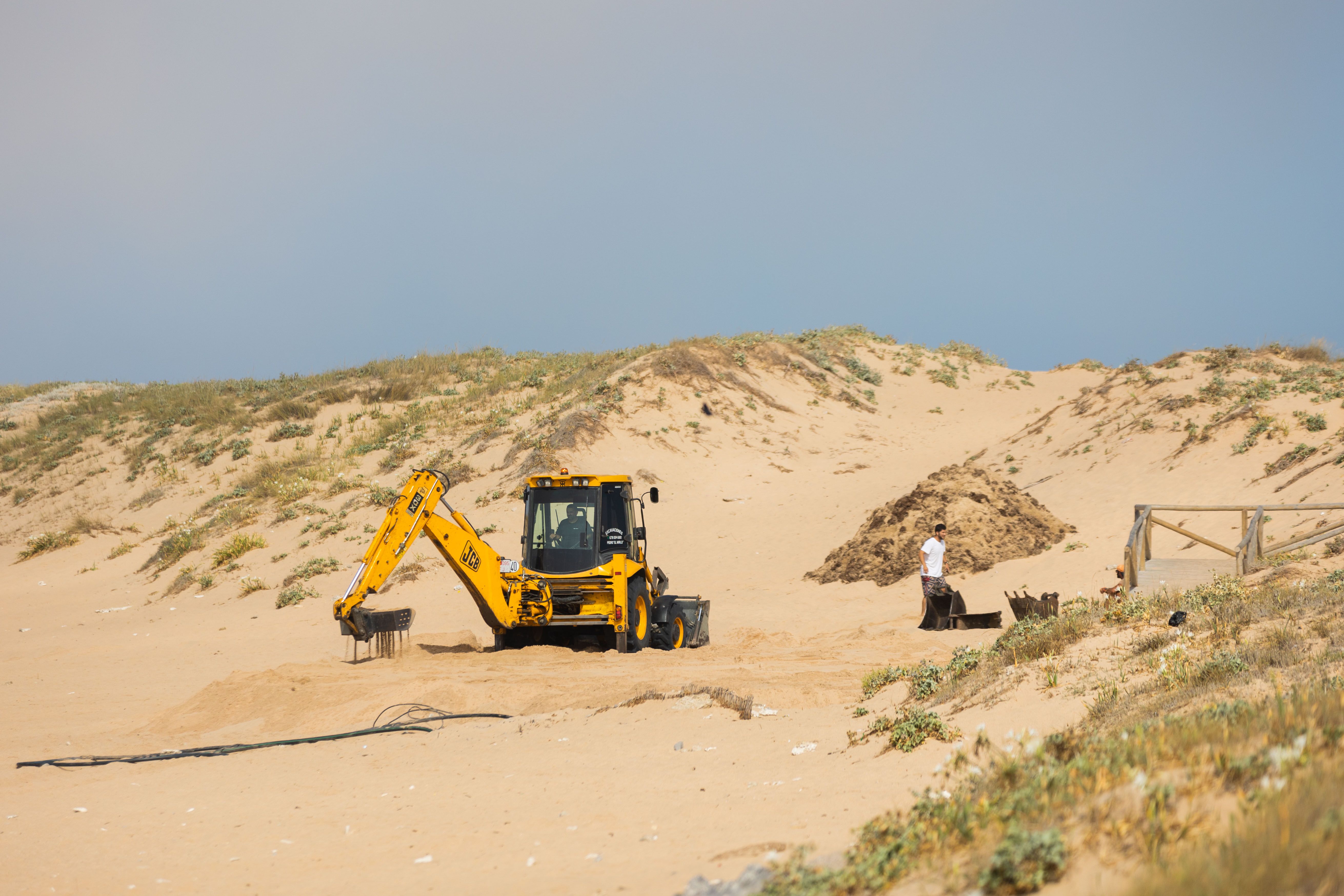 Tractor colocando la plataforma de un chiringuito.