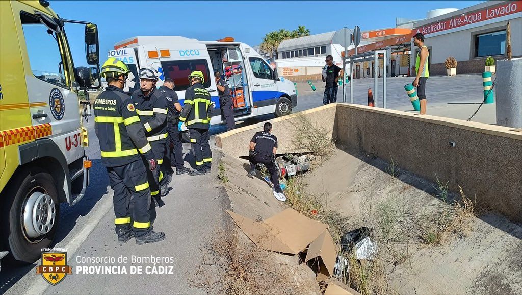 Bomberos, en las labores de rescate de la moto y el motorista. 