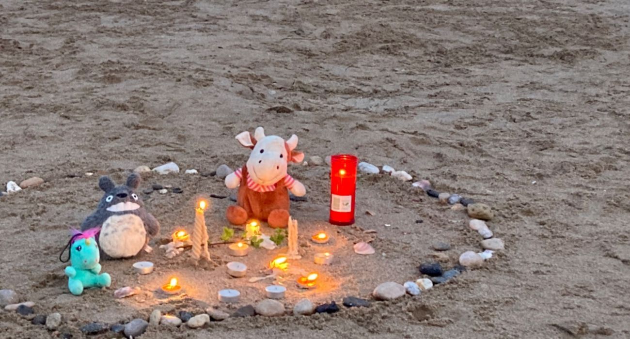 Velas en recuerdo de la pequeña hallada muerta en la orilla de una playa.