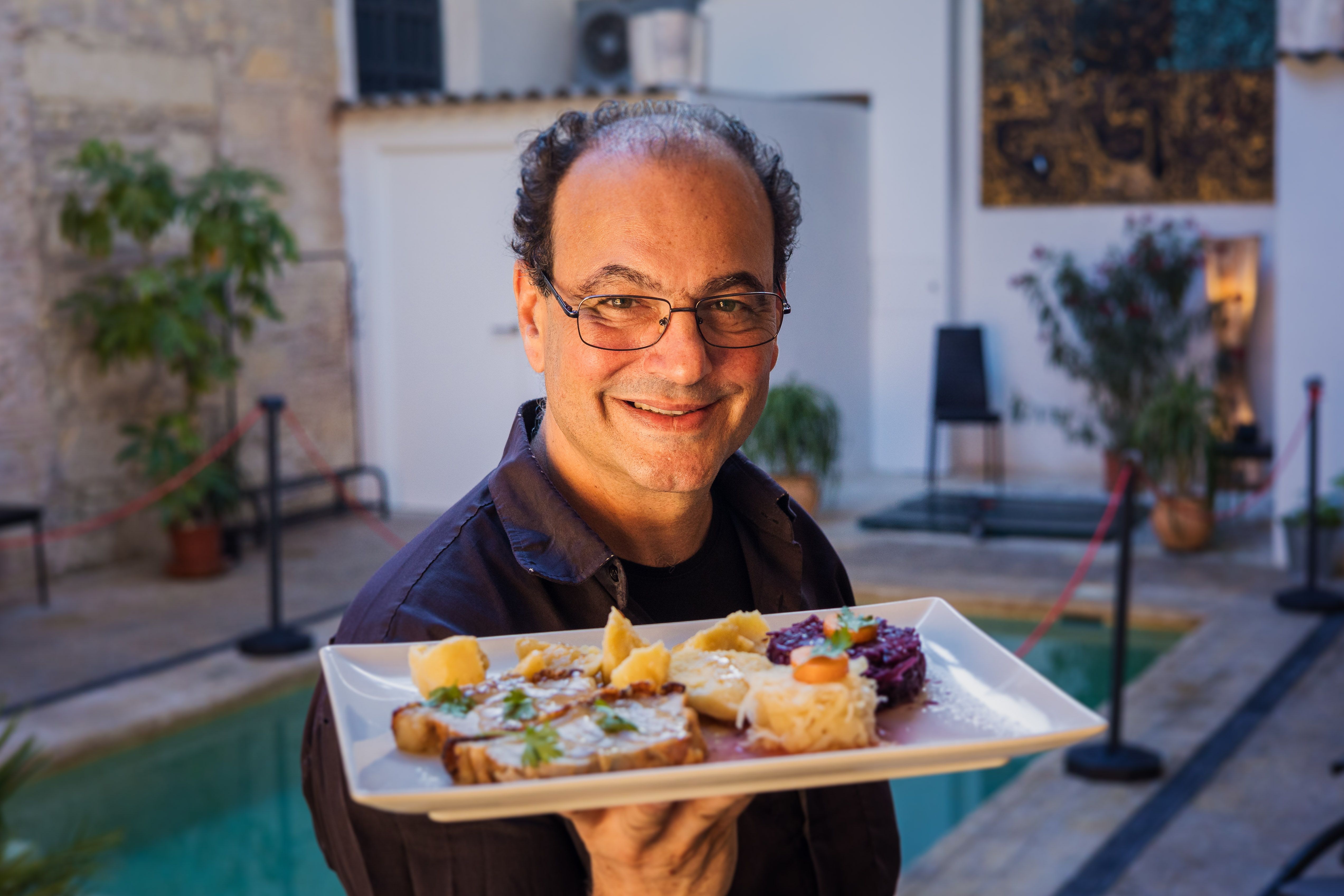 Remi mostrando uno de los platos alemanes que preparan en el restaurante. MANU GARCÍA