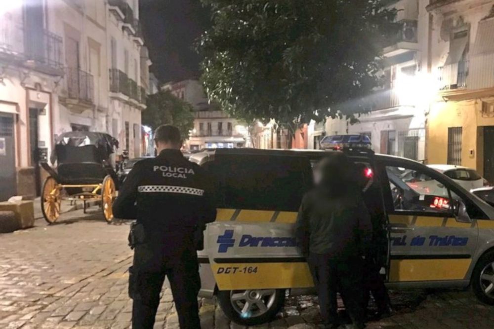 El coche de caballos, a la izquierda, mientras loas agentes realizan el control al conductor. FOTO: @emergenciassev