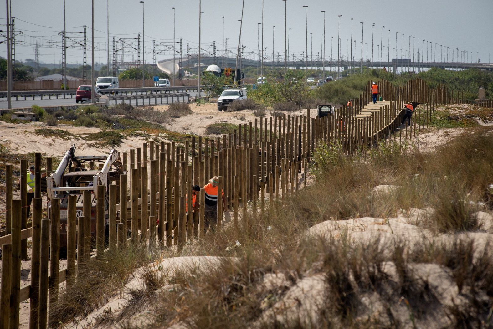 Los operarios trabajan en la construcción del trazado entre las dunas de Cortadura y la autovía Cádiz-San Fernando.