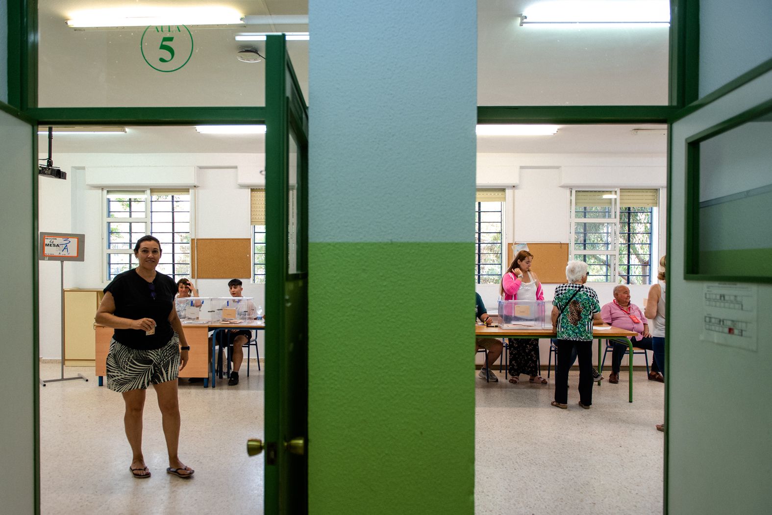 Una imagen de la jornada electoral con una persona al fondo votando en la urna.