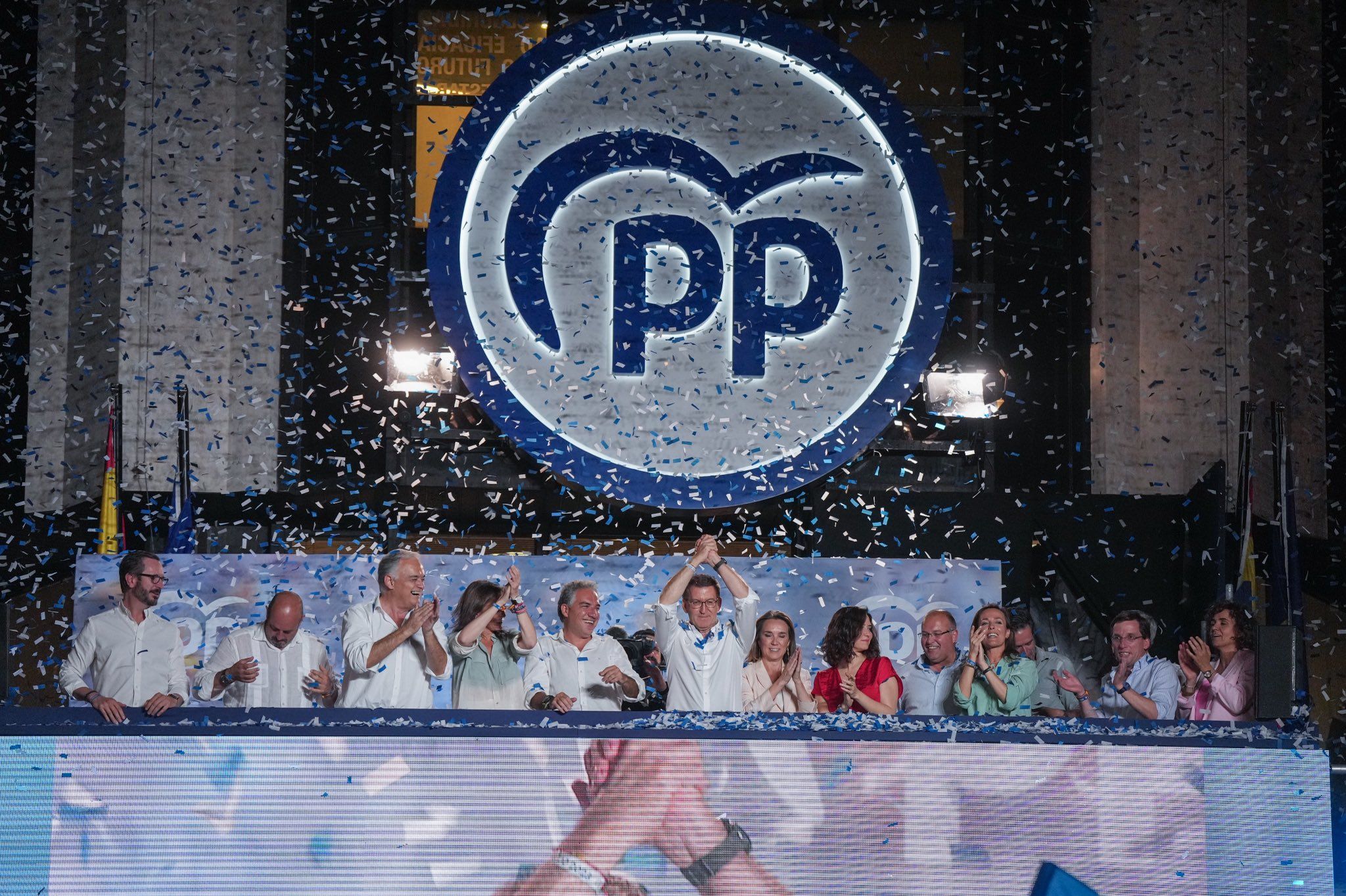Alberto Núñez Feijóo, líder del PP, celebra su victoria electoral junto a miembros del partido en Génova.