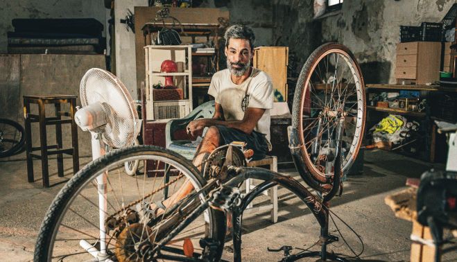 Memba junto a una de las bicis que repara para darle una segunda vida. JUAN CARLOS TORO