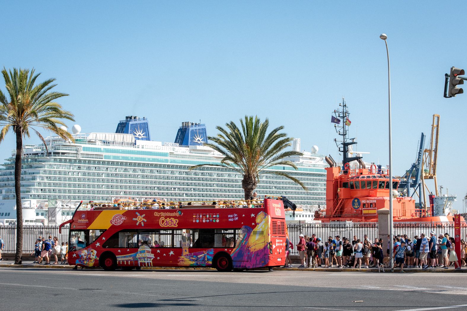 Un autobús turístico espera a los ocupantes de un gran crucero atracado en el puerto de Cádiz. 