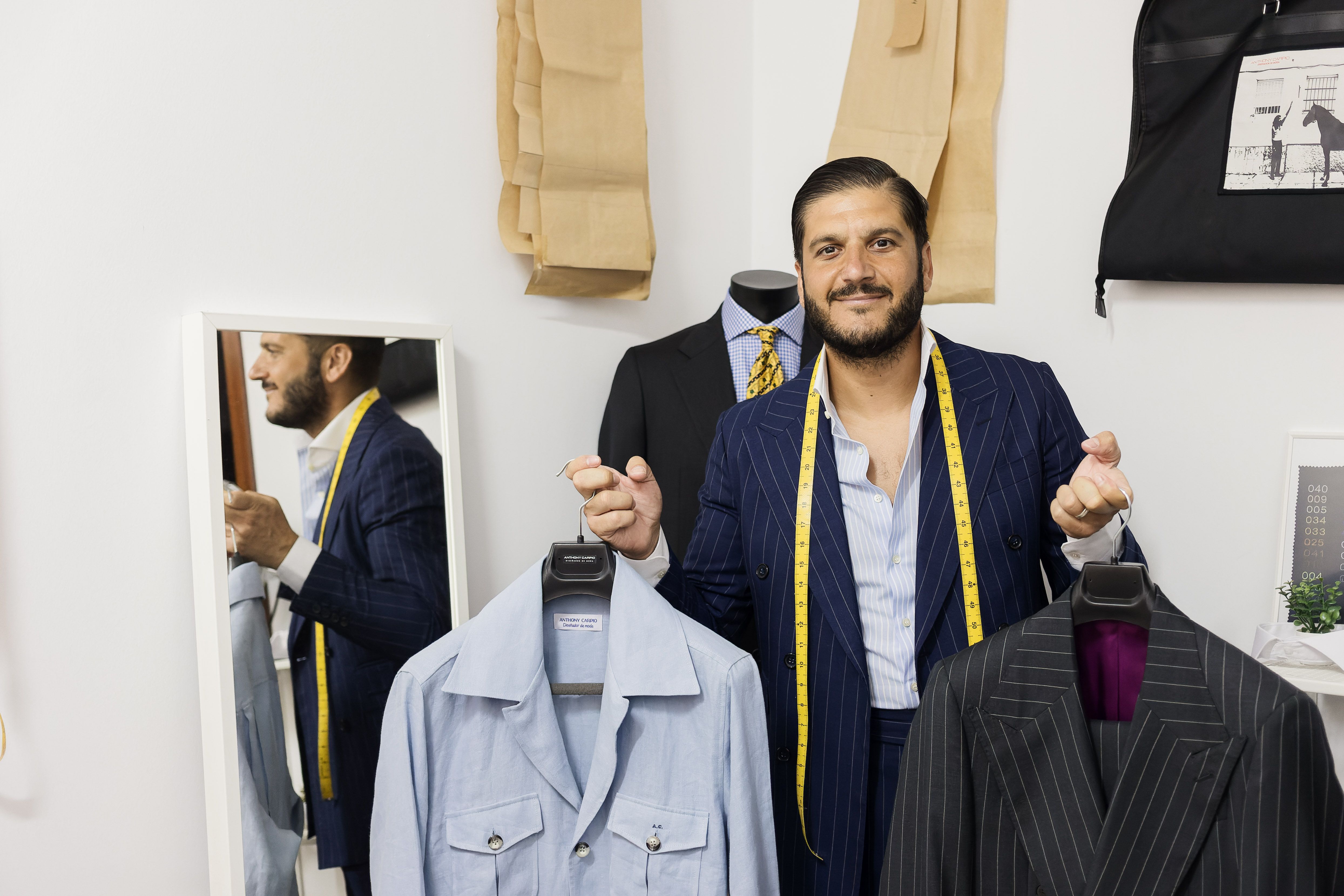 Carpio revestido de diseñador con dos piezas terminadas en sus manos. CADELA NÚÑEZ